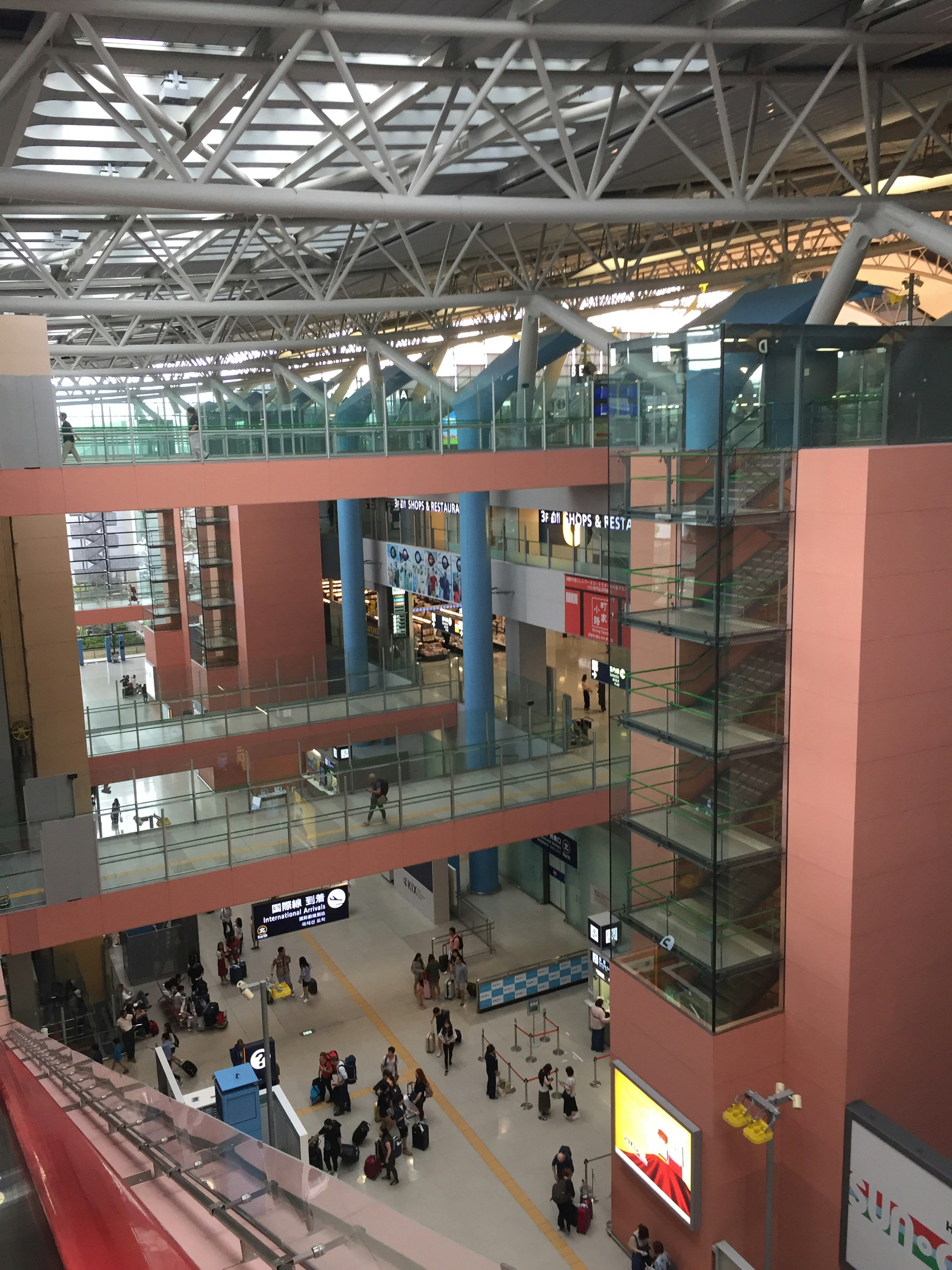 Spacious modern airport lobby featuring glass railings and steel structure