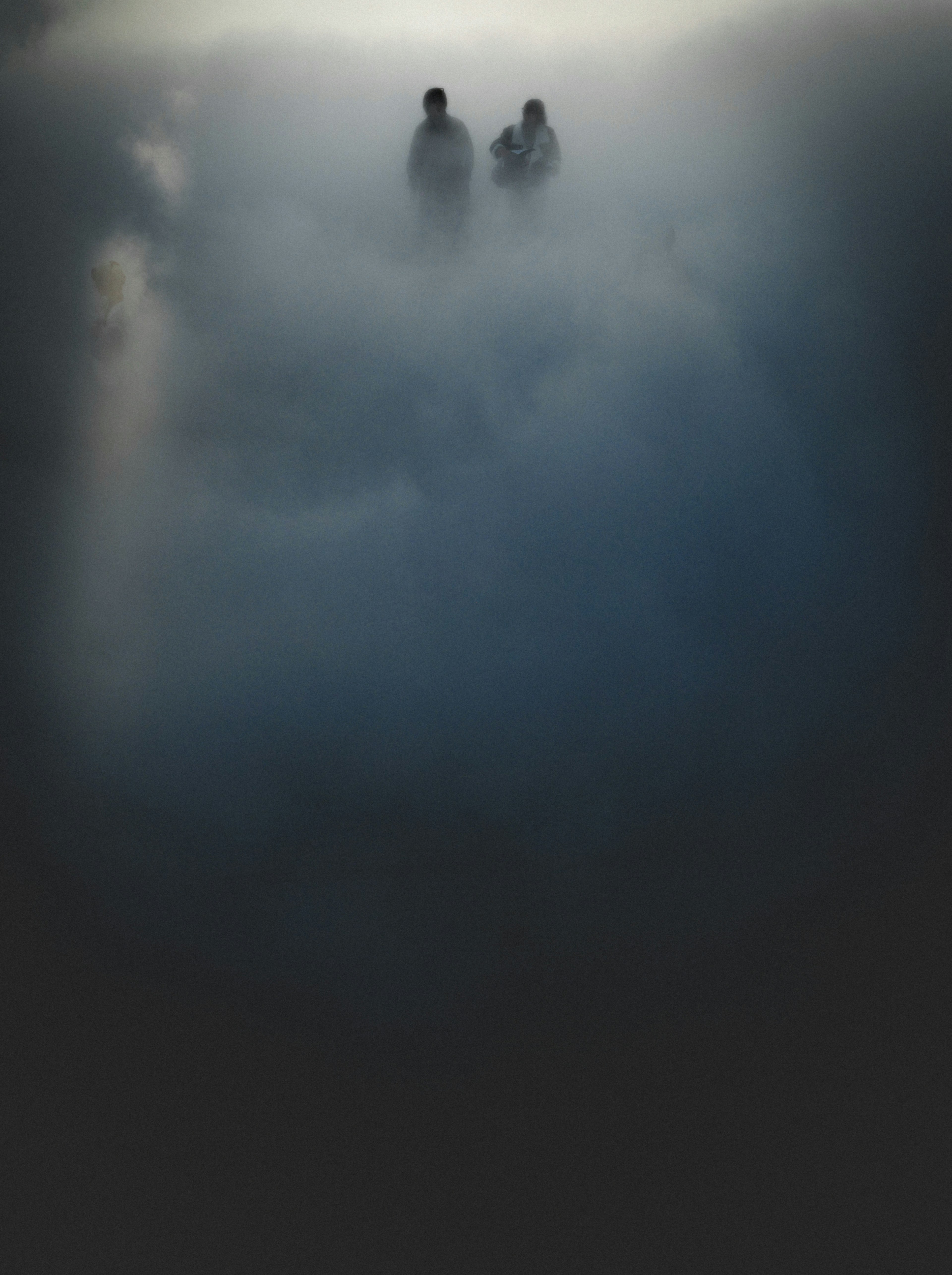 Silhouettes of two people in fog