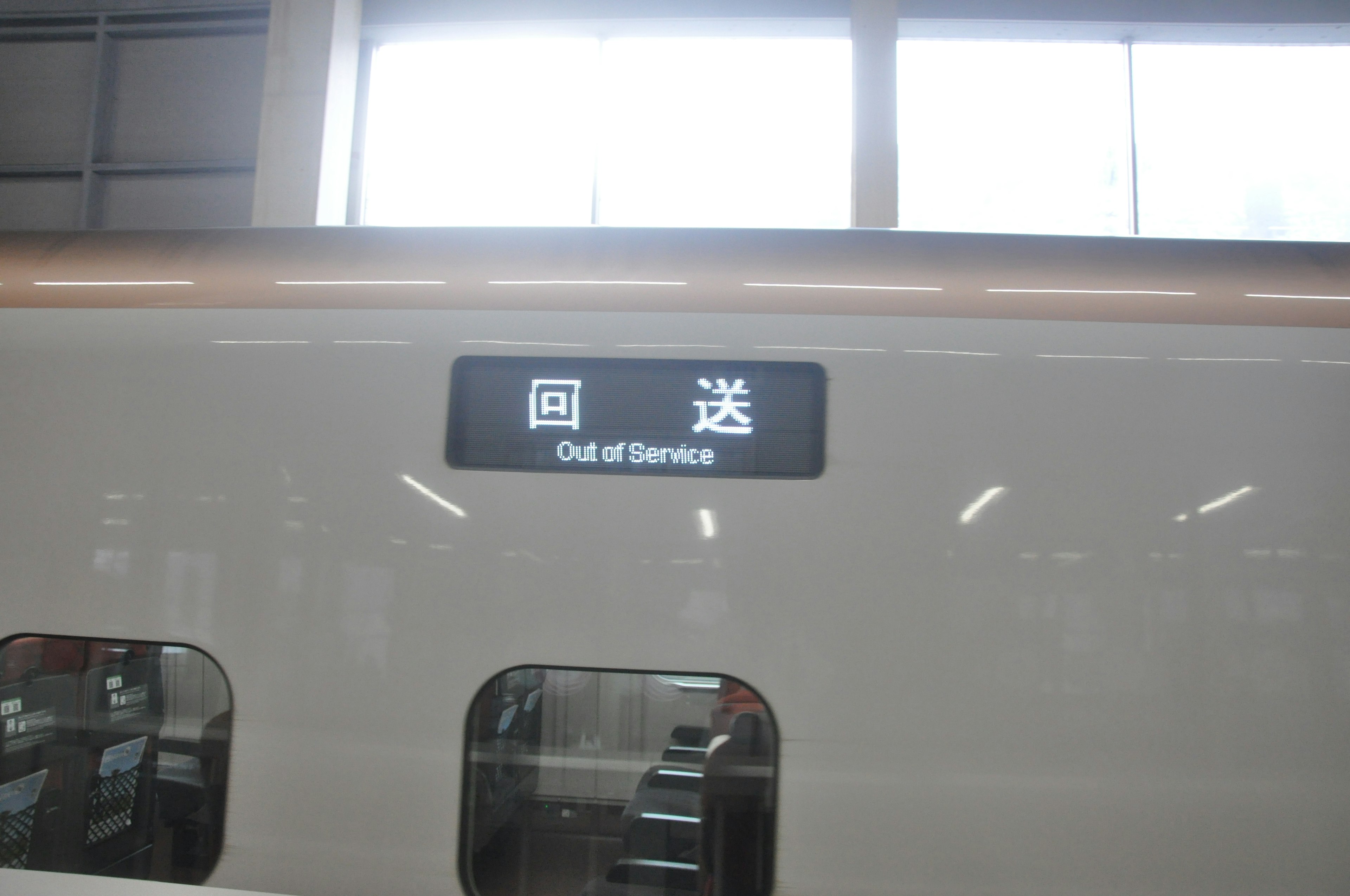 A white train with a sign displaying Out of Service