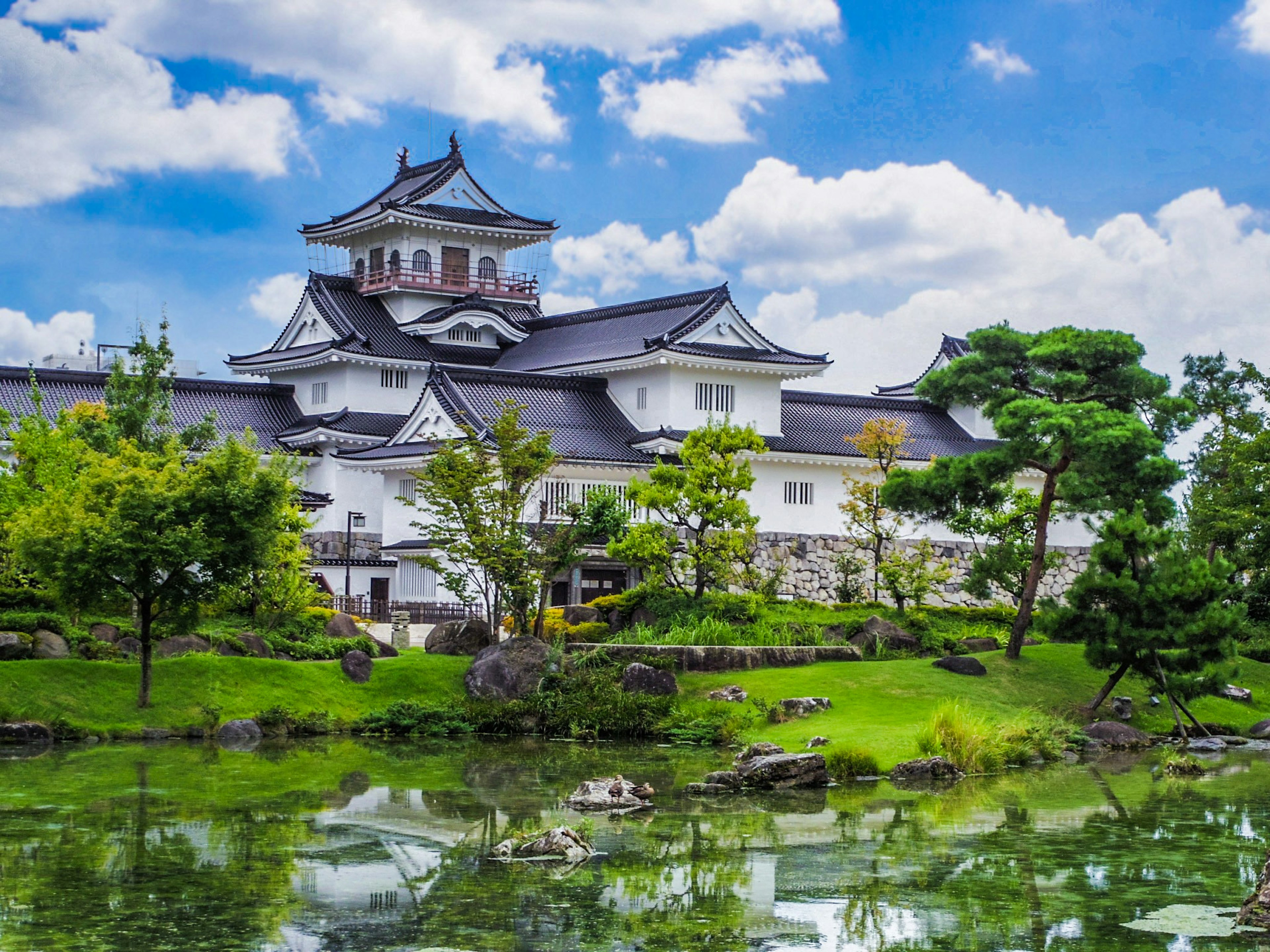 Magnifique château japonais reflété dans un étang serein entouré de verdure luxuriante