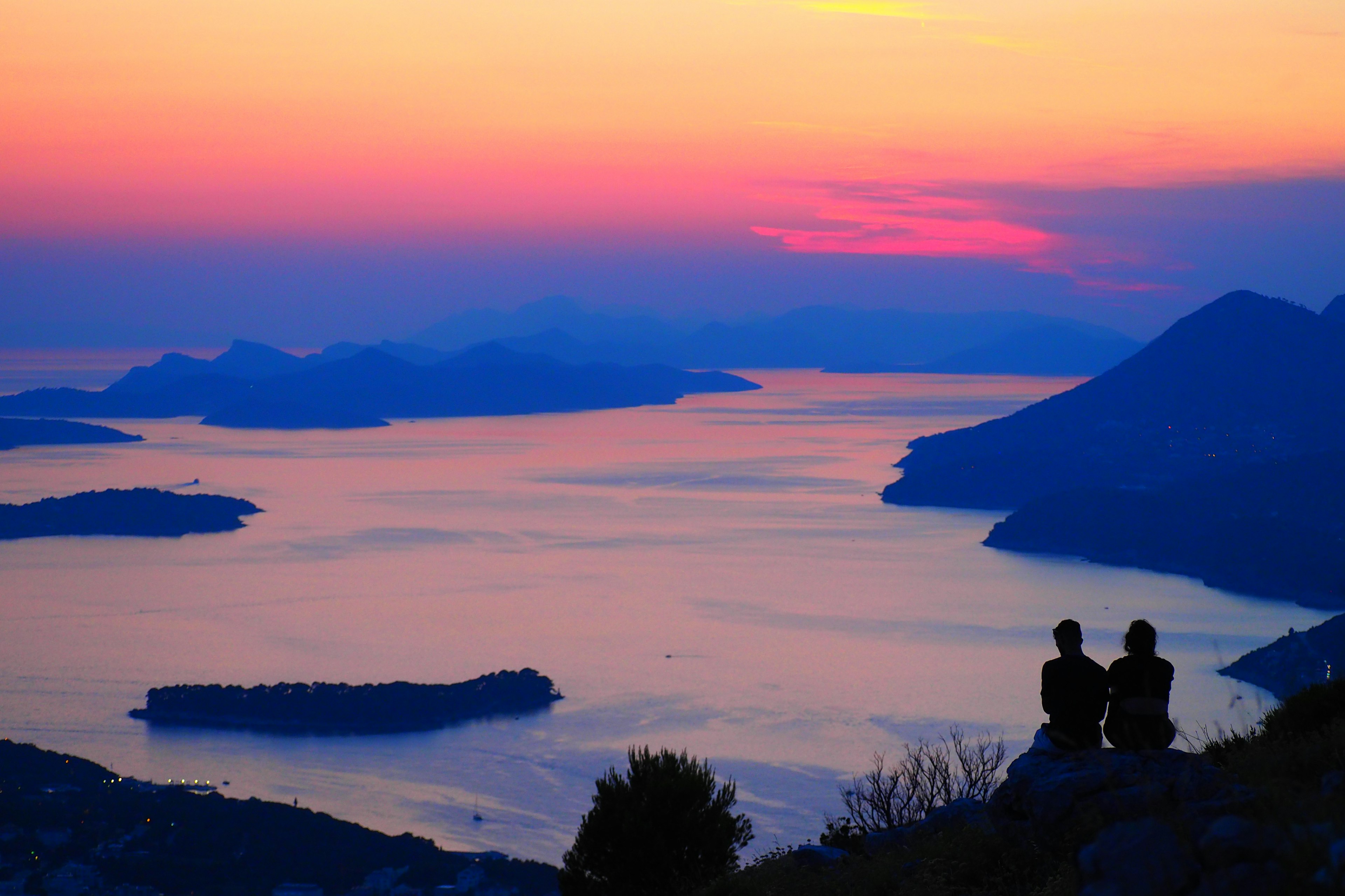 Pareja mirando el mar y las islas al atardecer