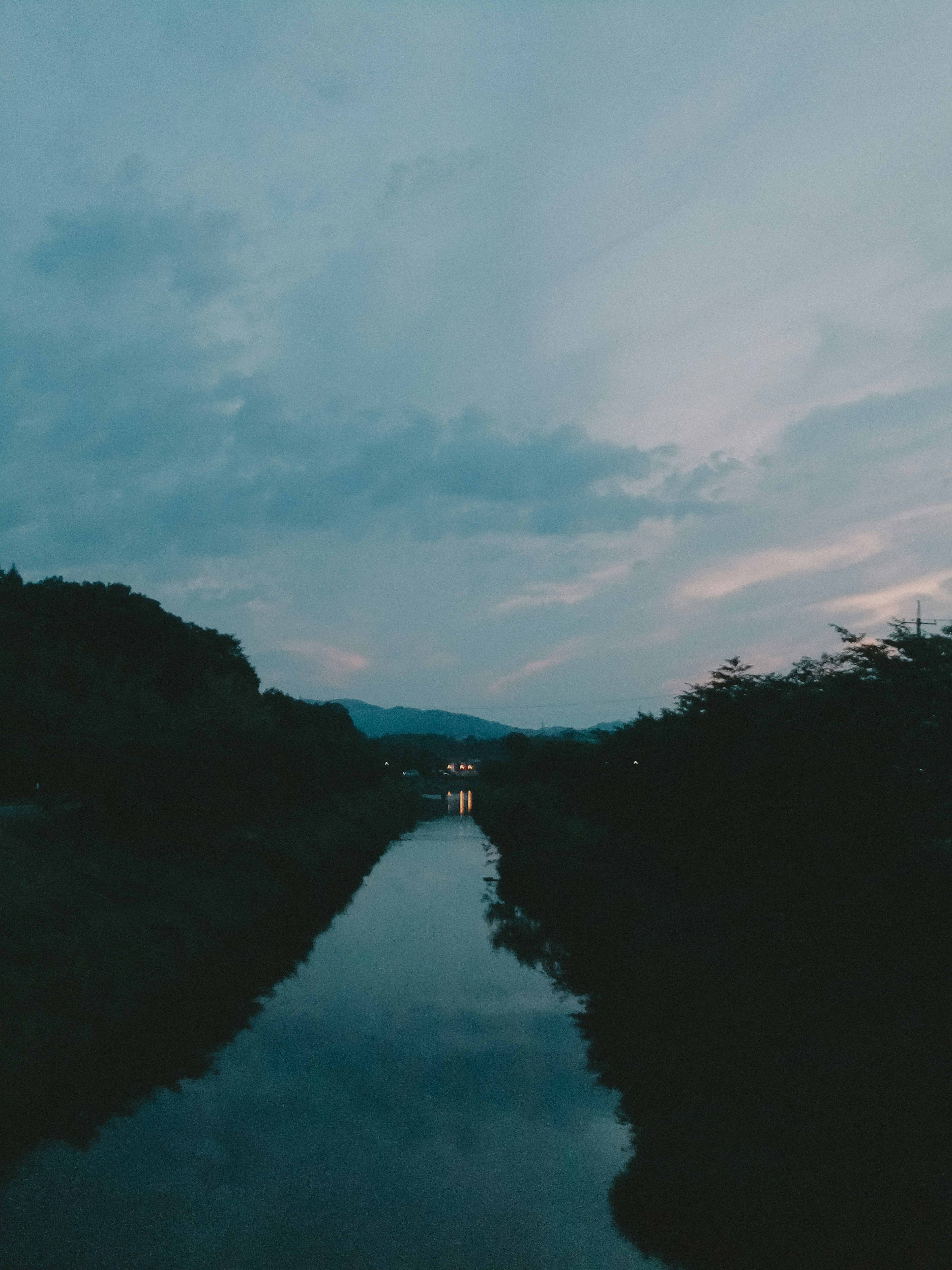 Refleksi sungai tenang dengan langit senja