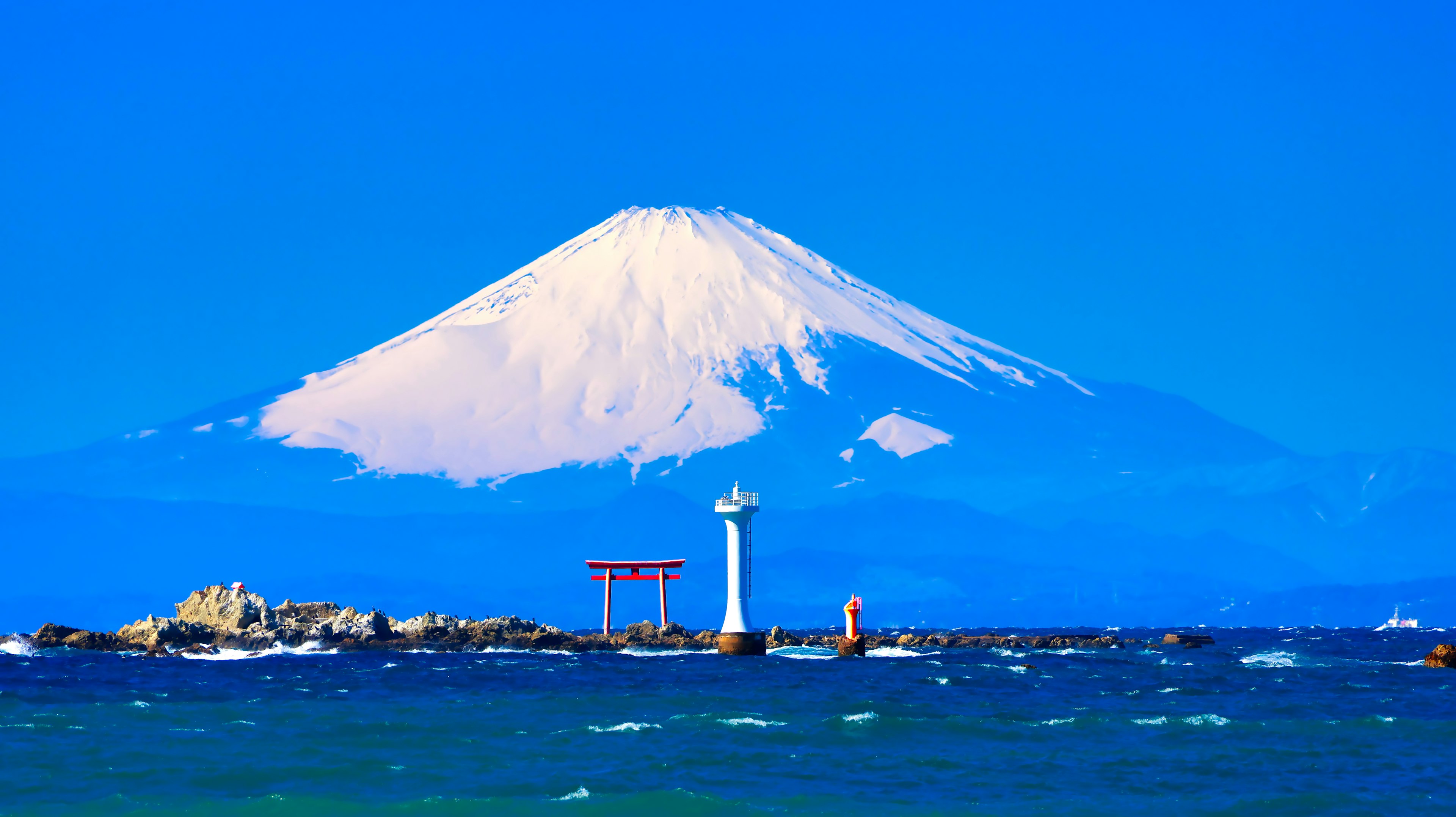 Gunung Fuji menjulang di bawah langit biru dikelilingi lautan