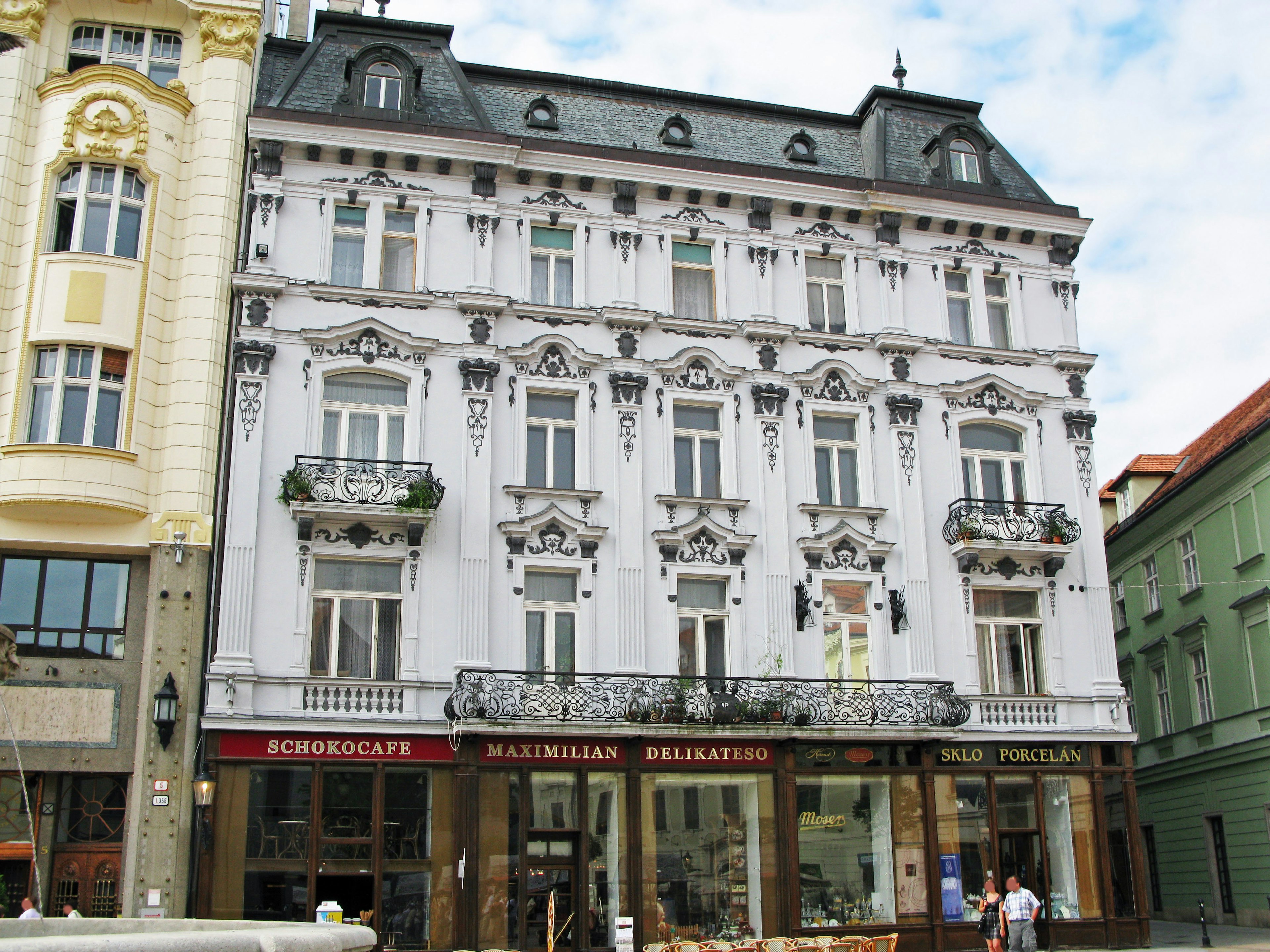 Historic building with ornate white facade and balconies in urban setting