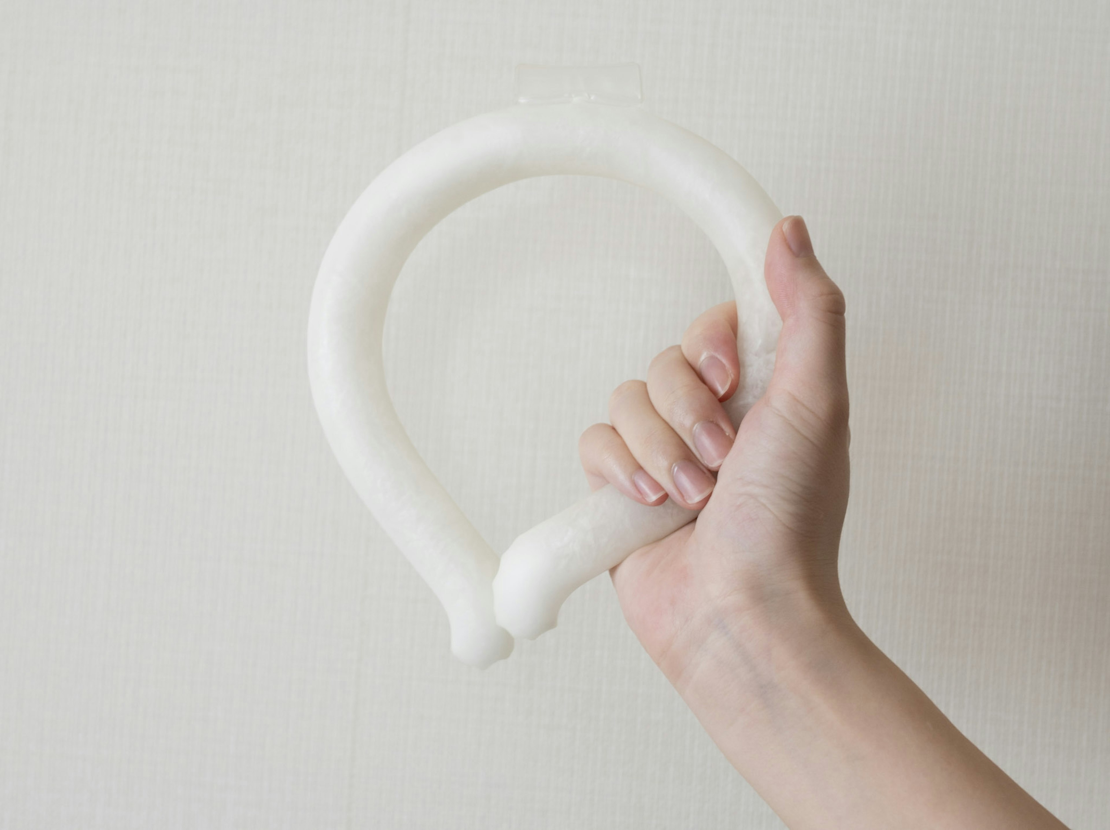 A hand holding a white circular object