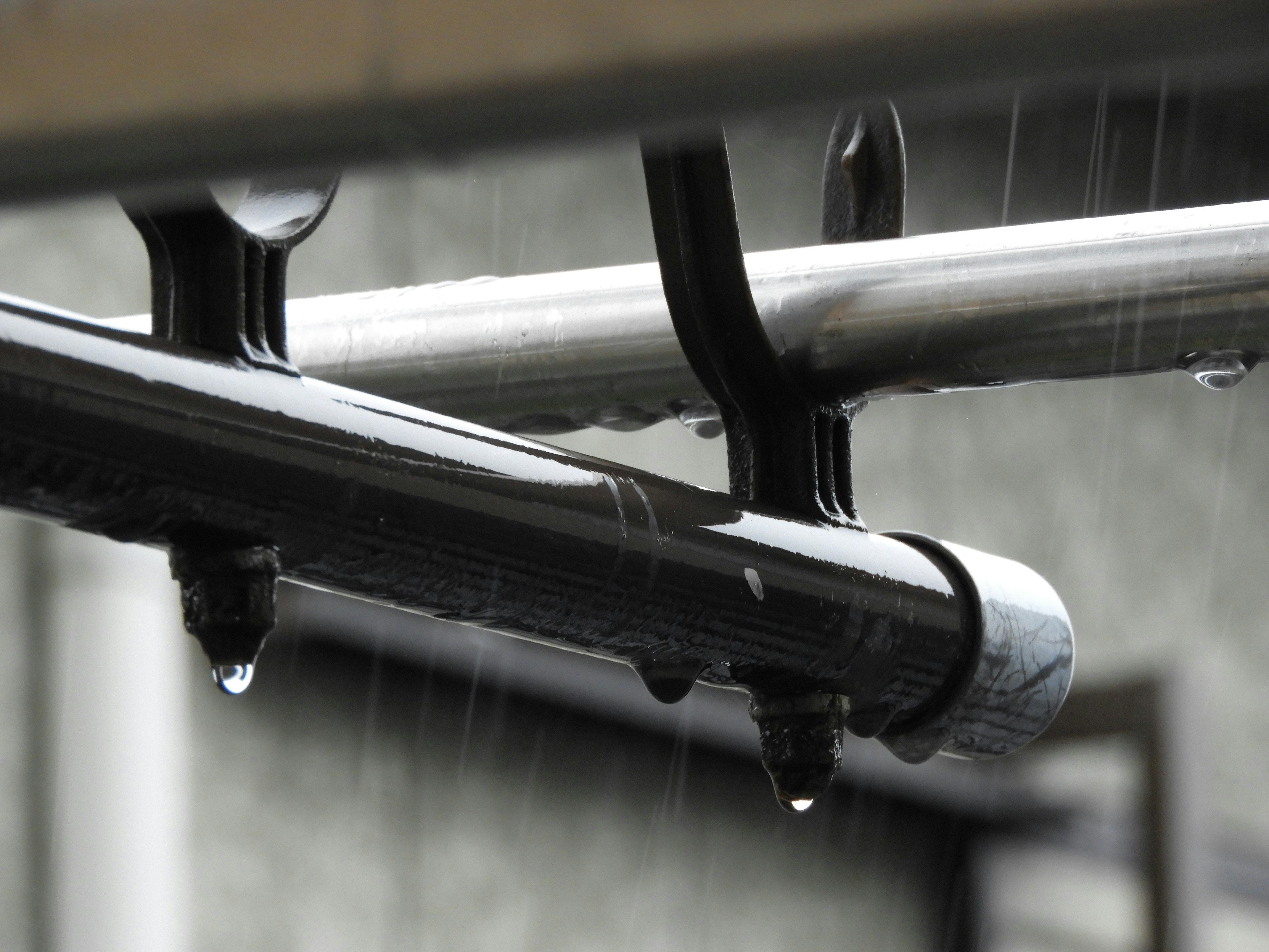 Gotas de agua cayendo de un tubo metálico