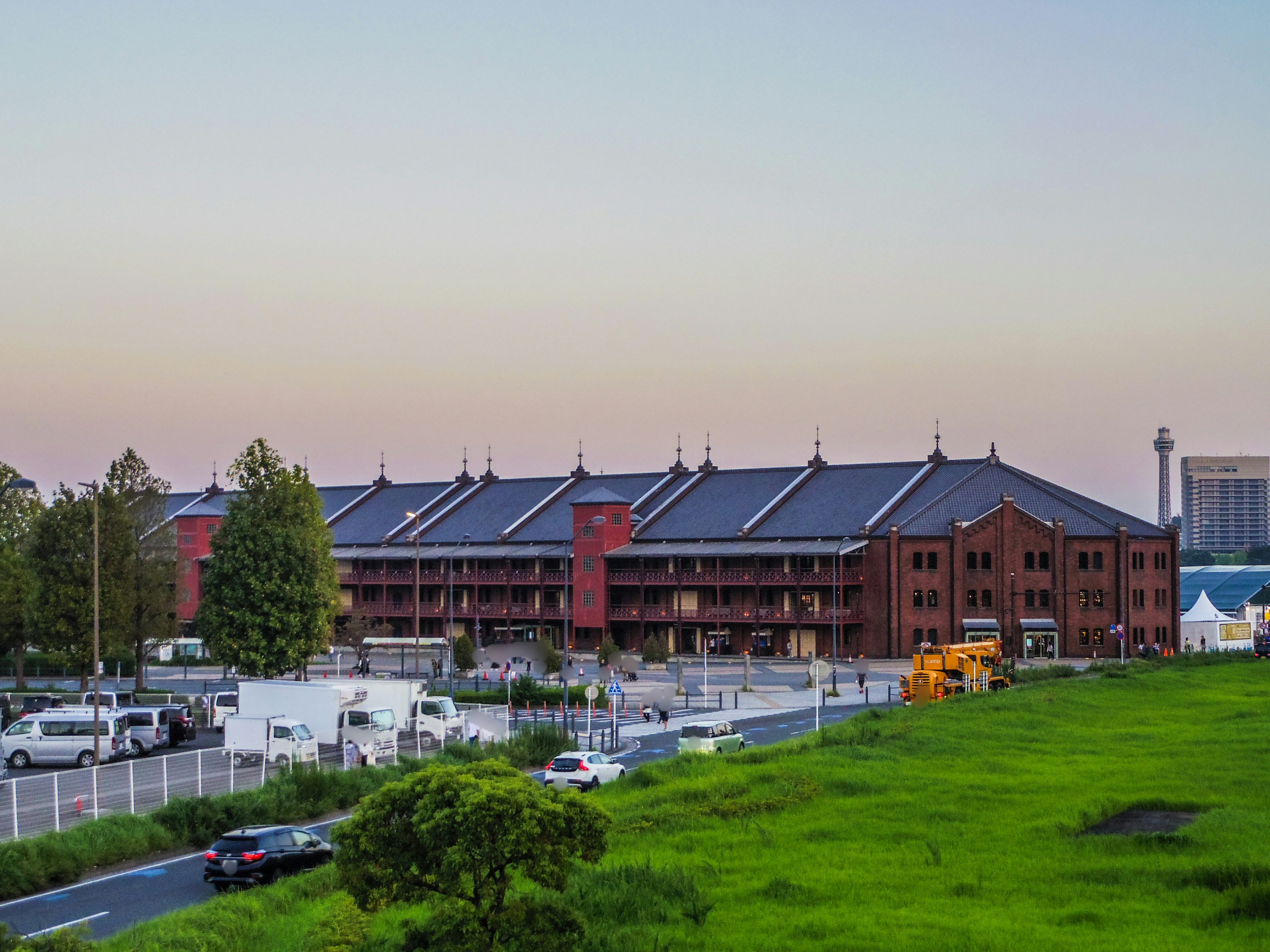 Rotes Backsteingebäude mit Blick auf den blauen Himmel Grünes Gras und Straße sichtbar