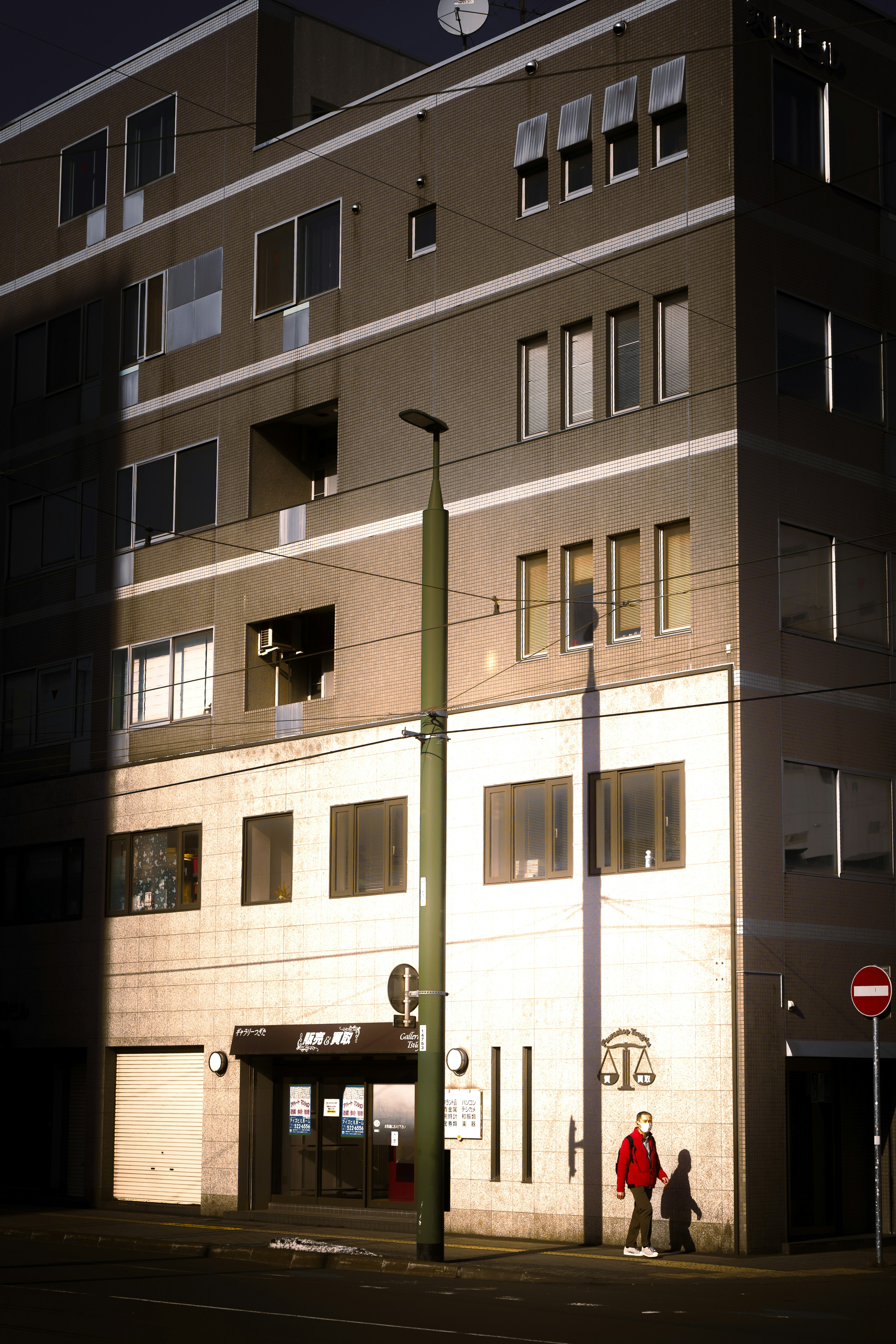 Modern building at night with illuminated facade and silhouettes of people