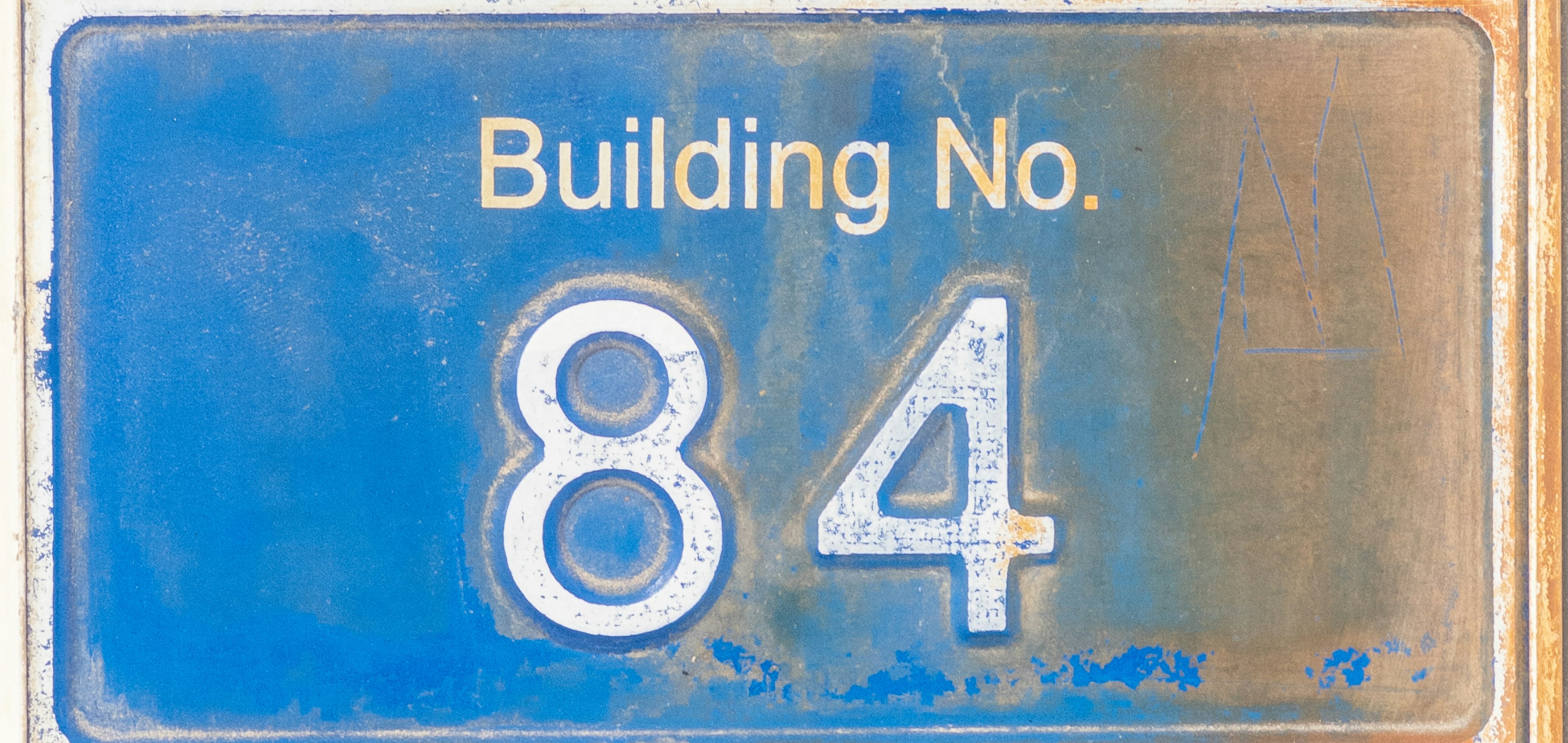 Blaues Schild mit der Gebäude-Nr 84