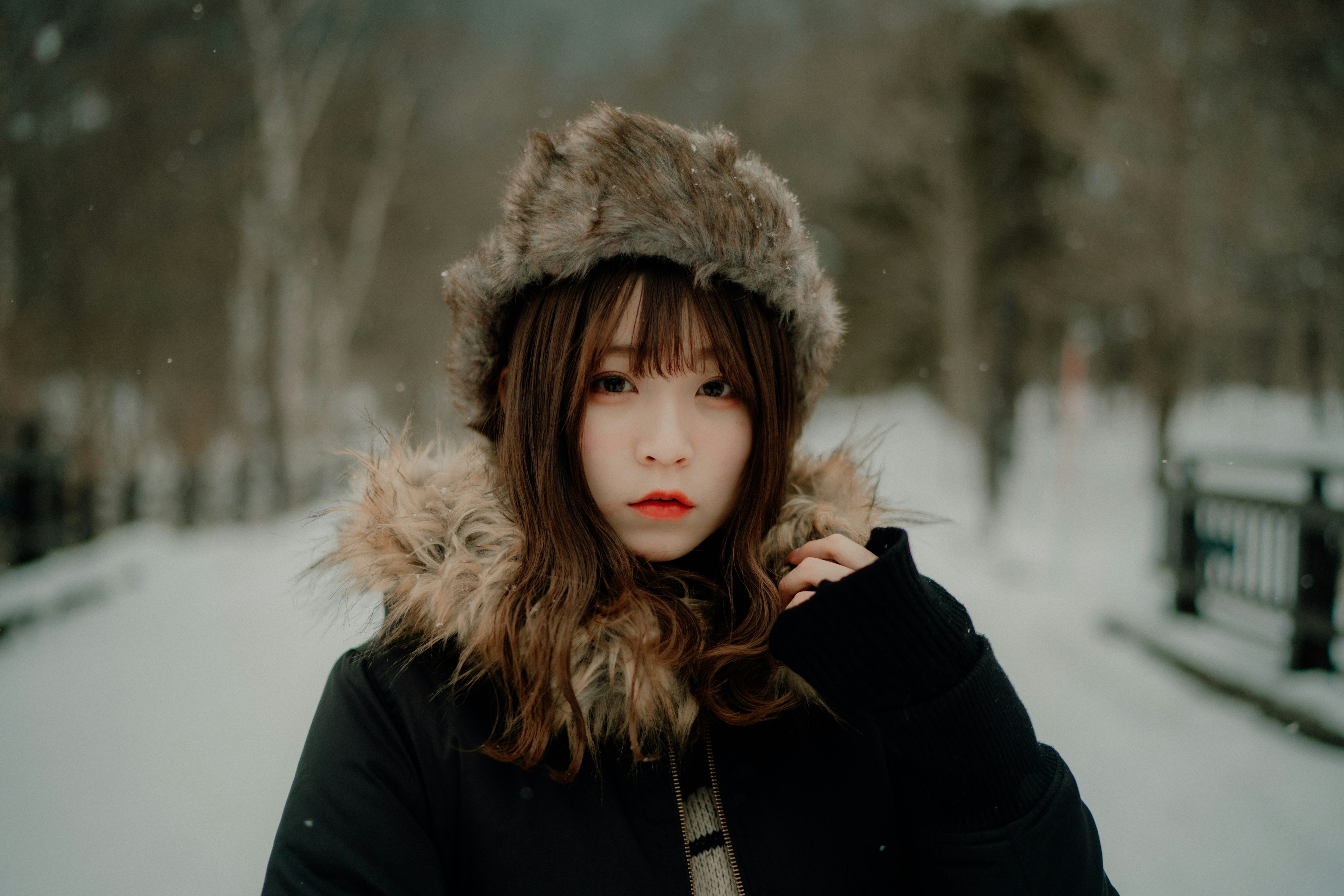 雪の中で暖かい帽子をかぶった女性のポートレート