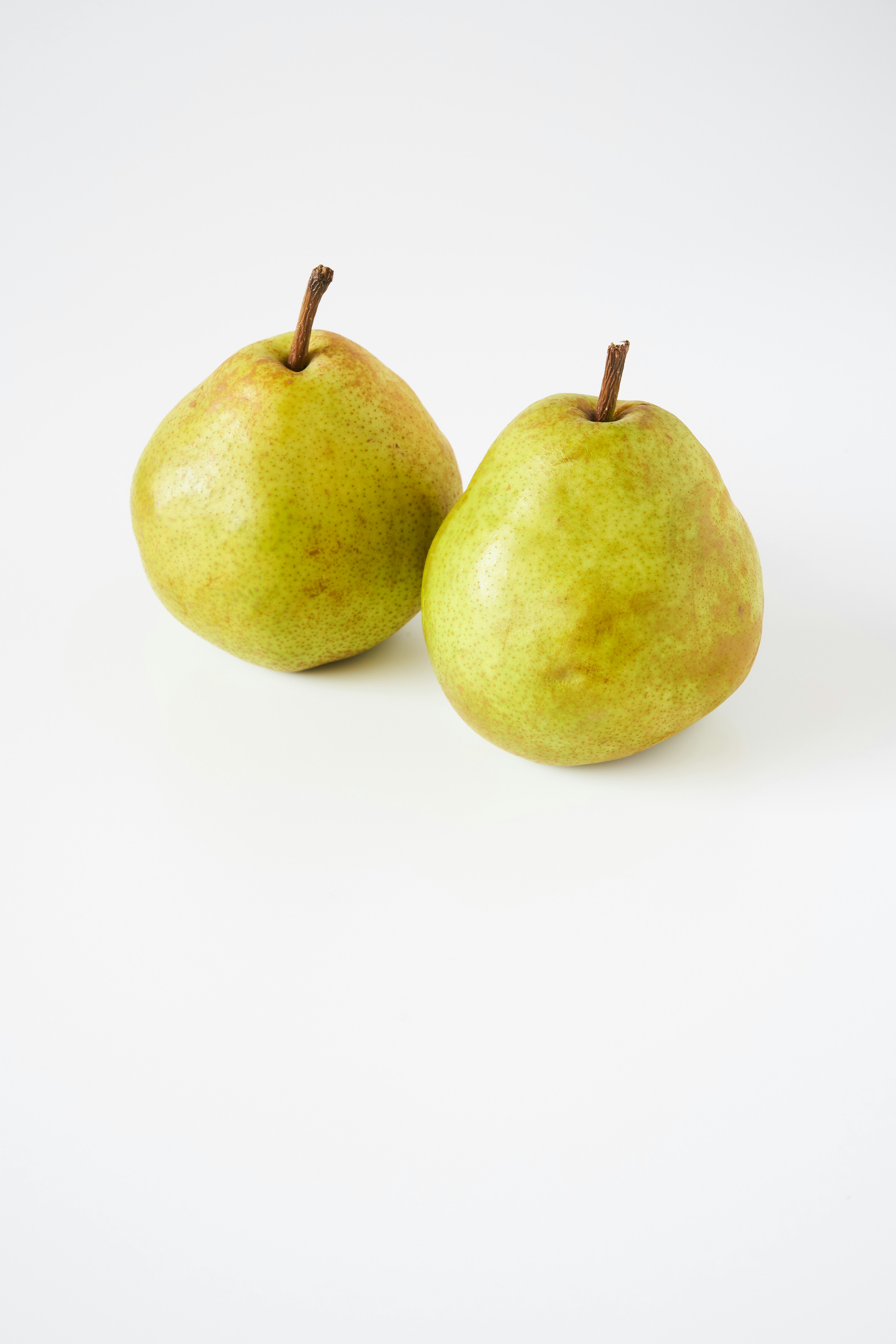 Two green pears on a white background