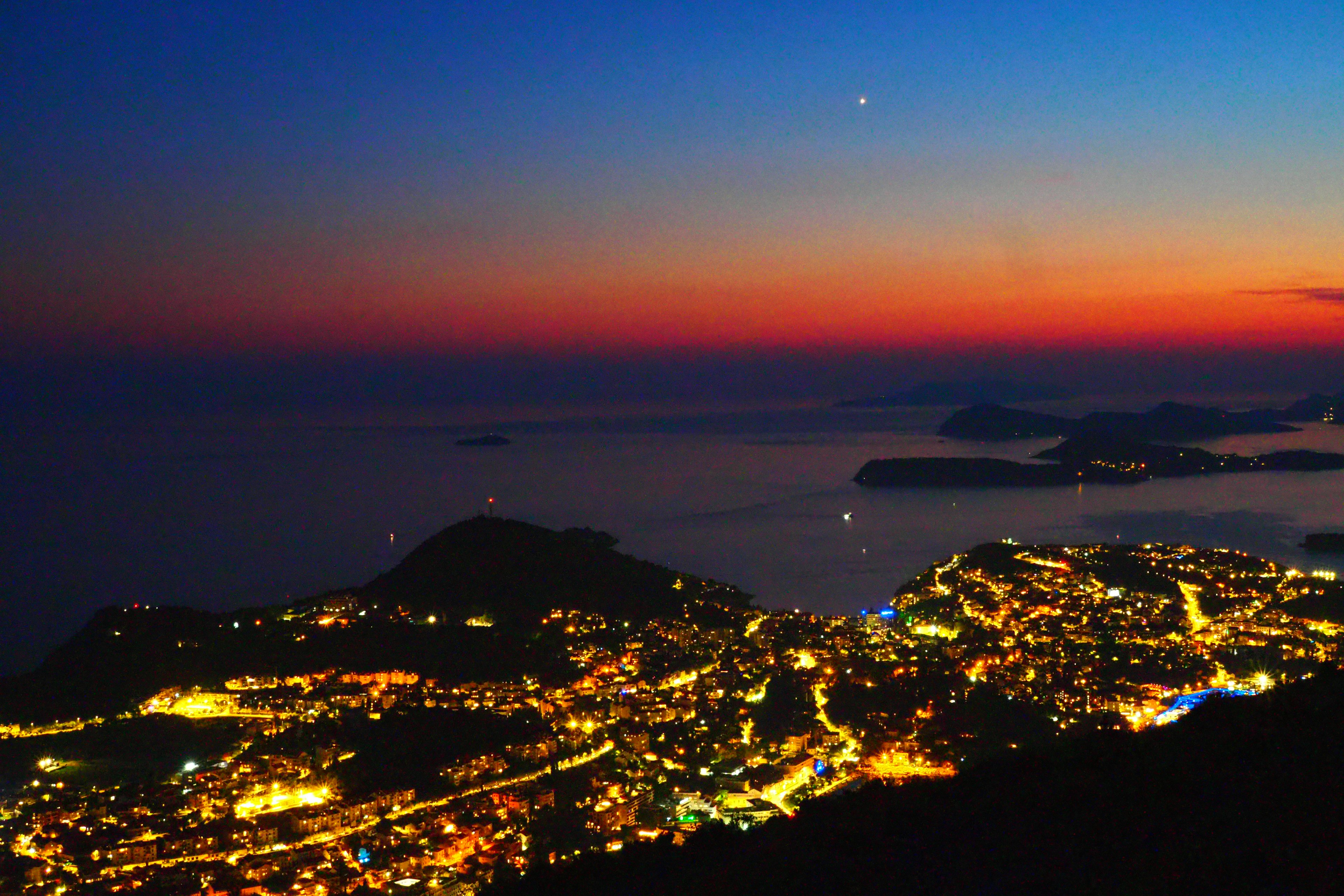 Una bella vista notturna costiera con luci della città e l'oceano