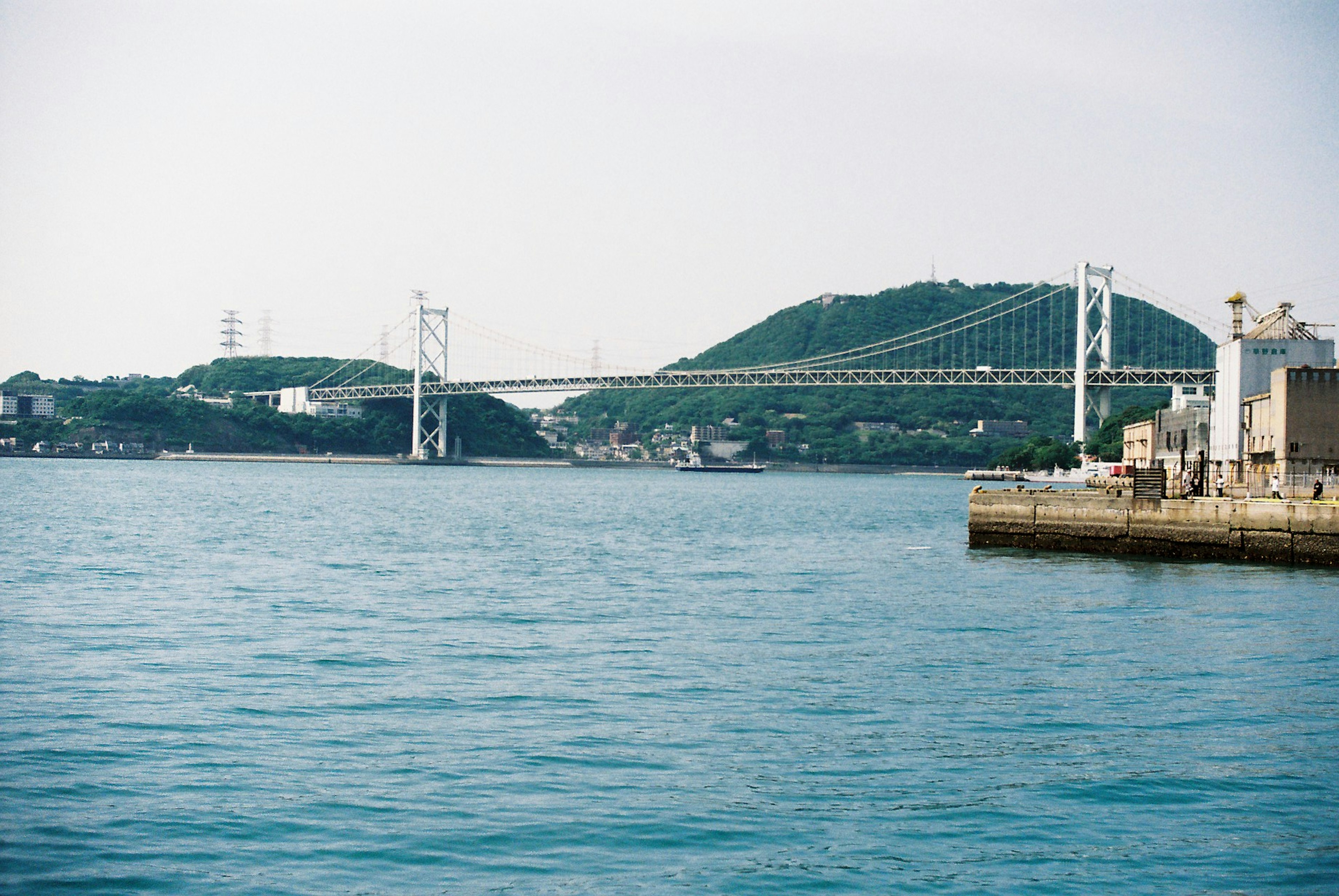 Un pont surplombant une mer calme avec un arrière-plan montagneux