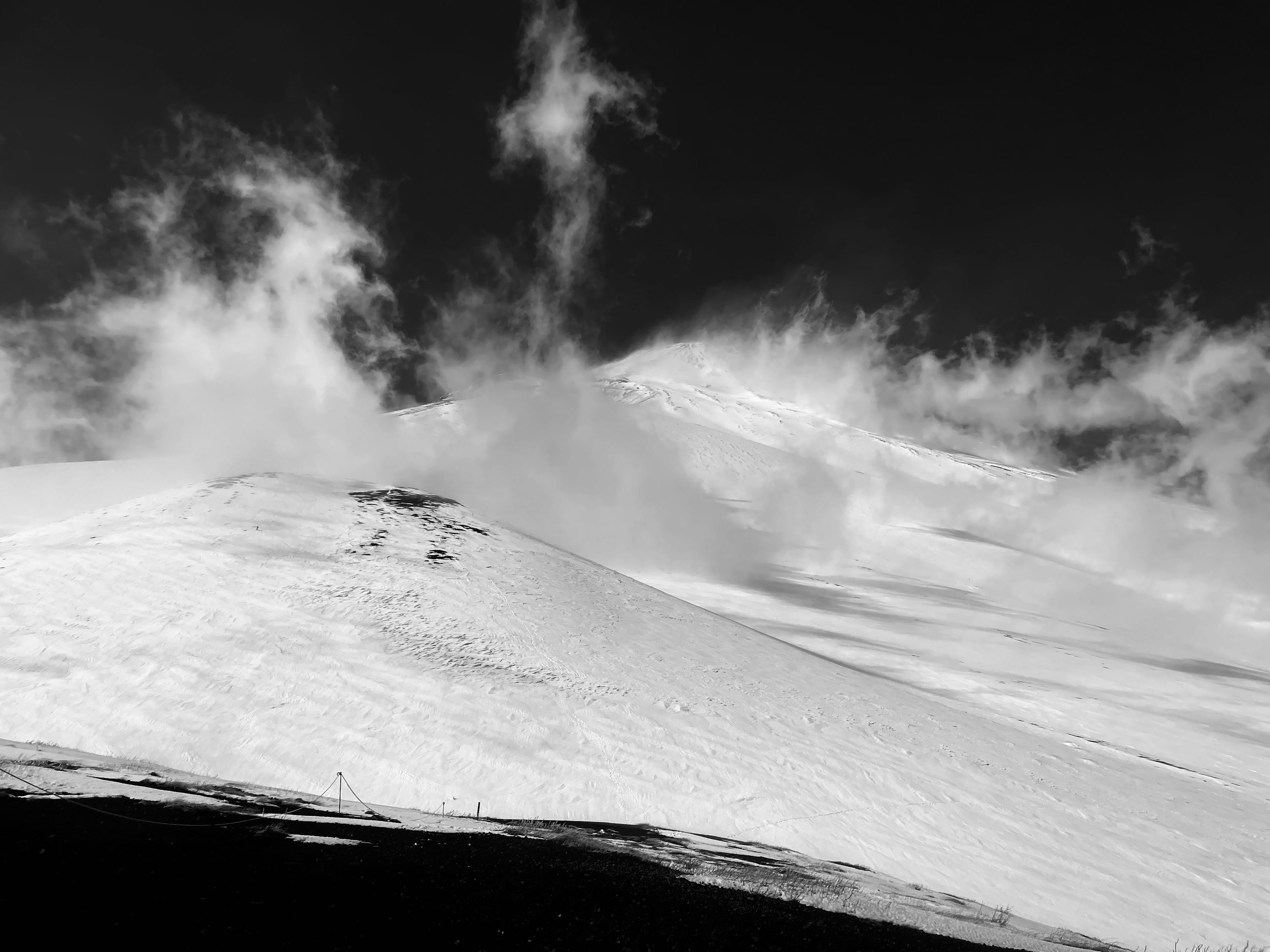 Snow-covered mountain landscape with flowing clouds