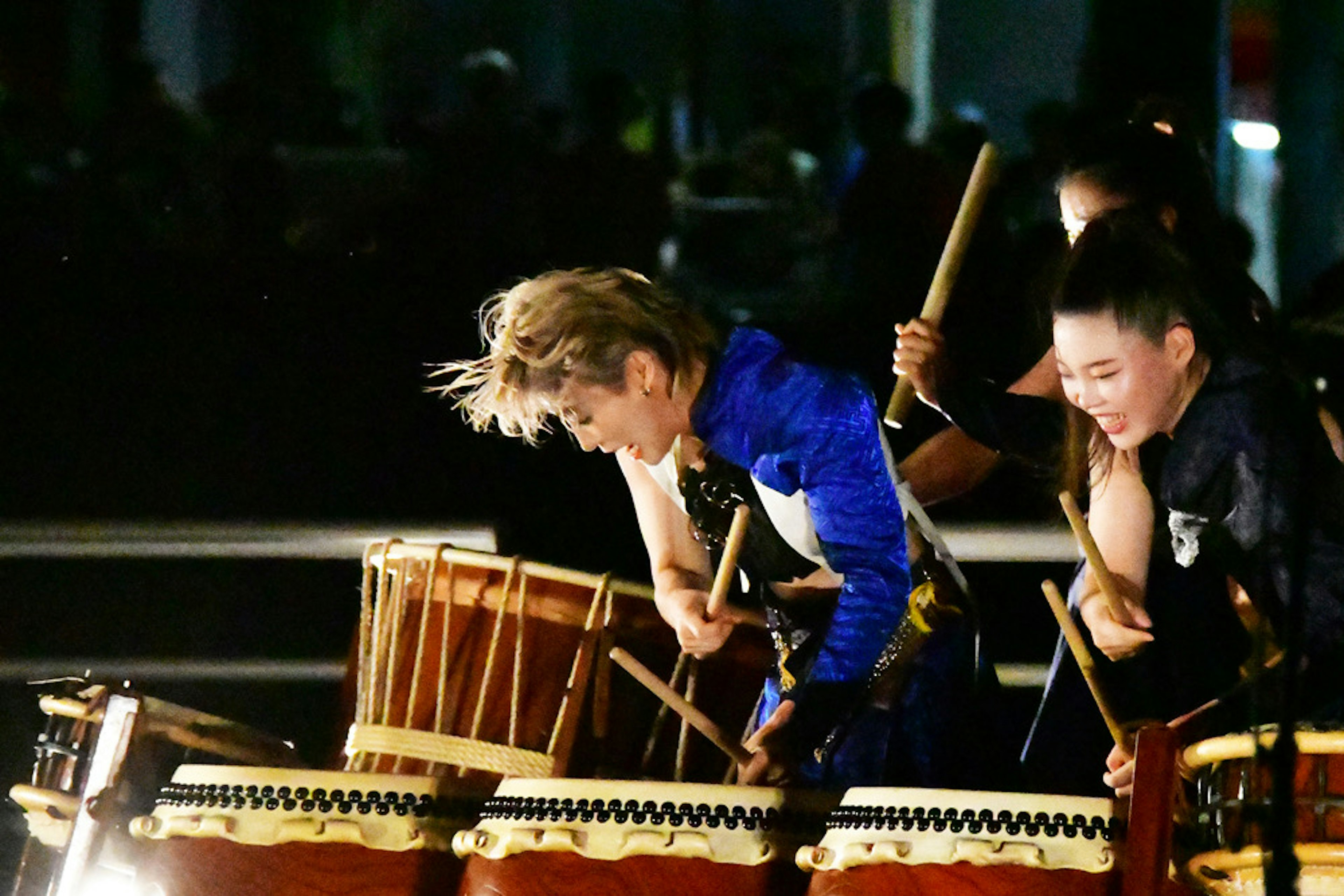 Perempuan yang tampil dengan drum tradisional di malam hari