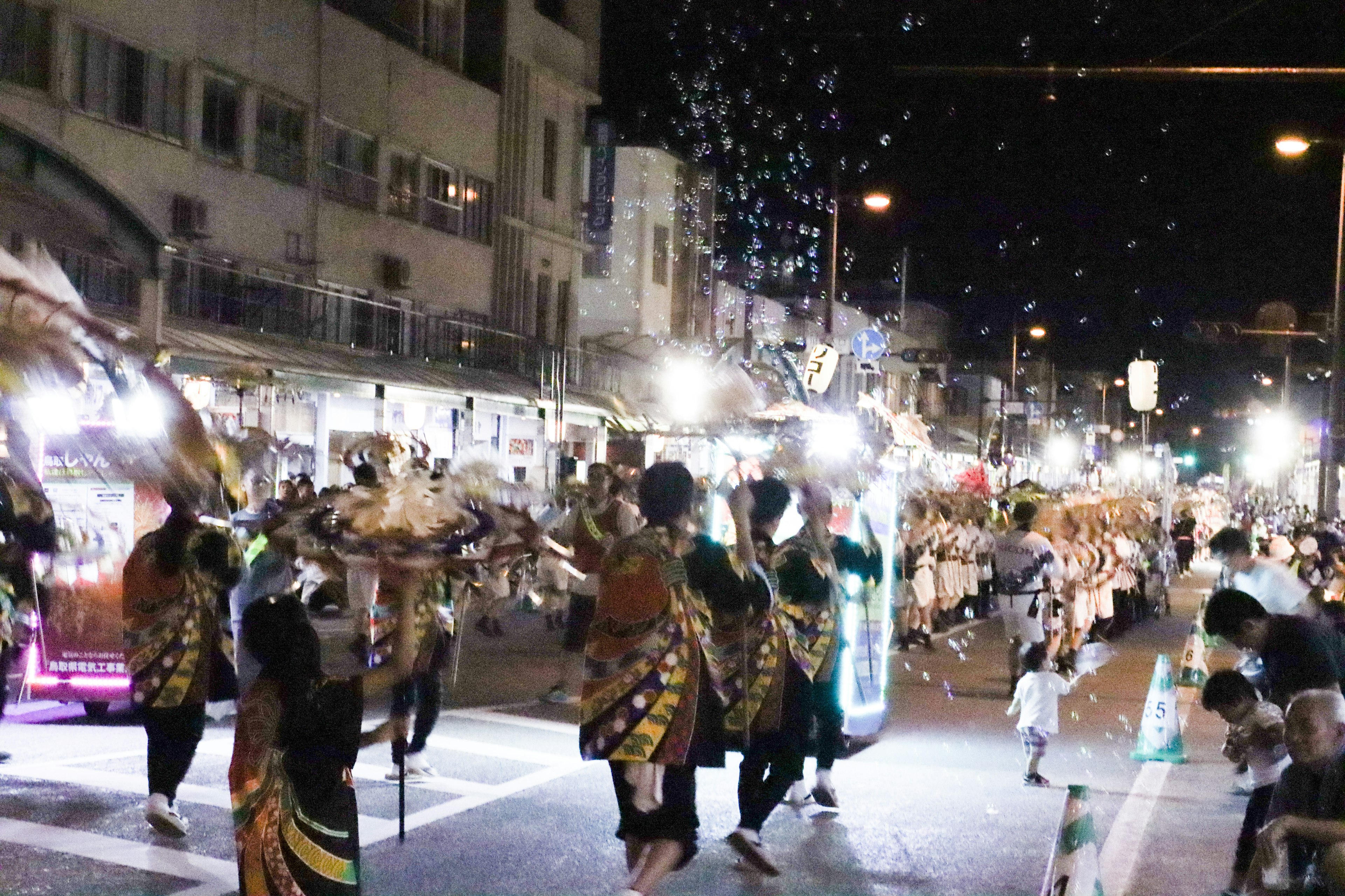 People dancing in a night parade with bright lights