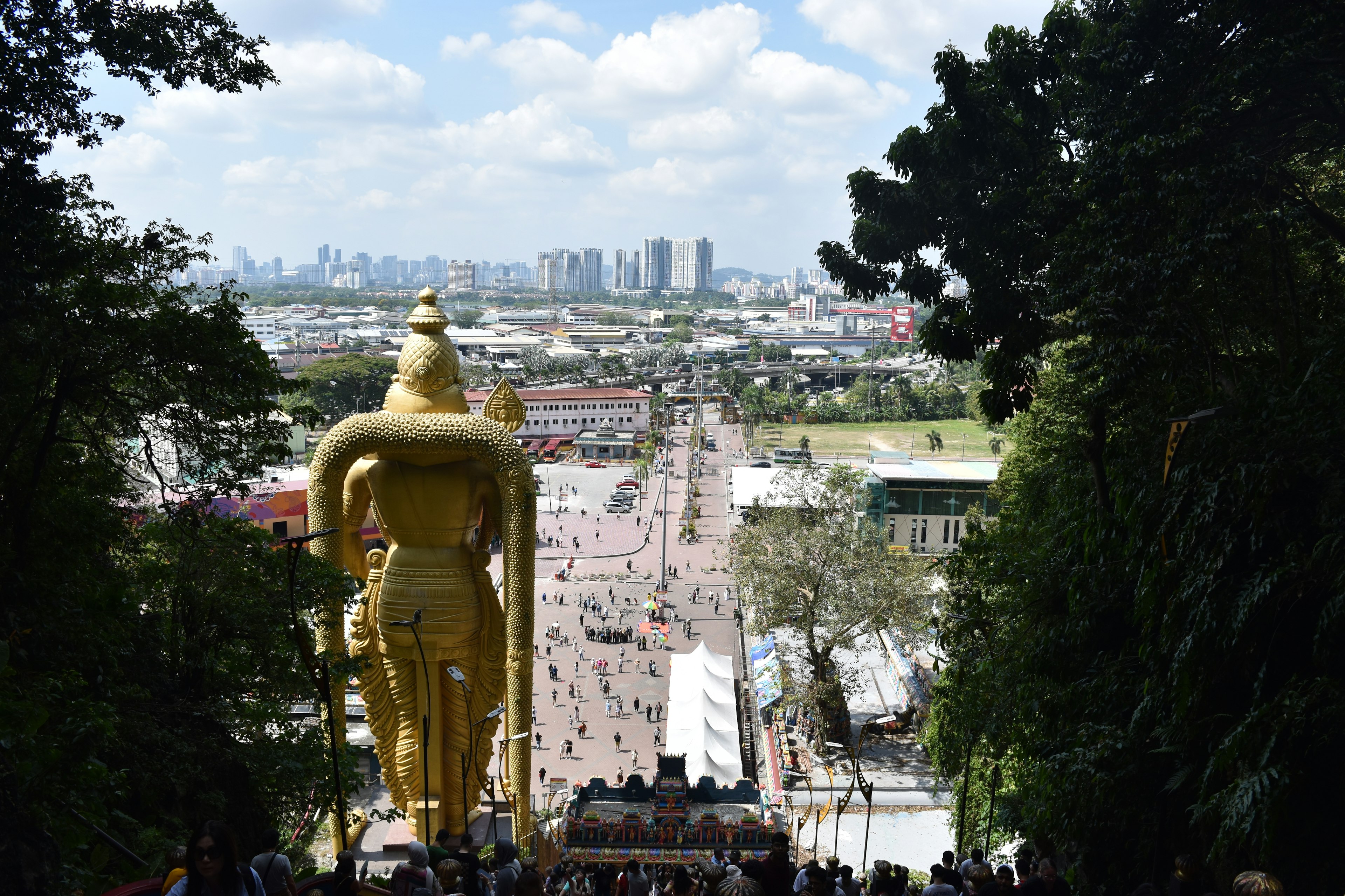 Gigante estatua de Buda dorada con vista a un horizonte urbano