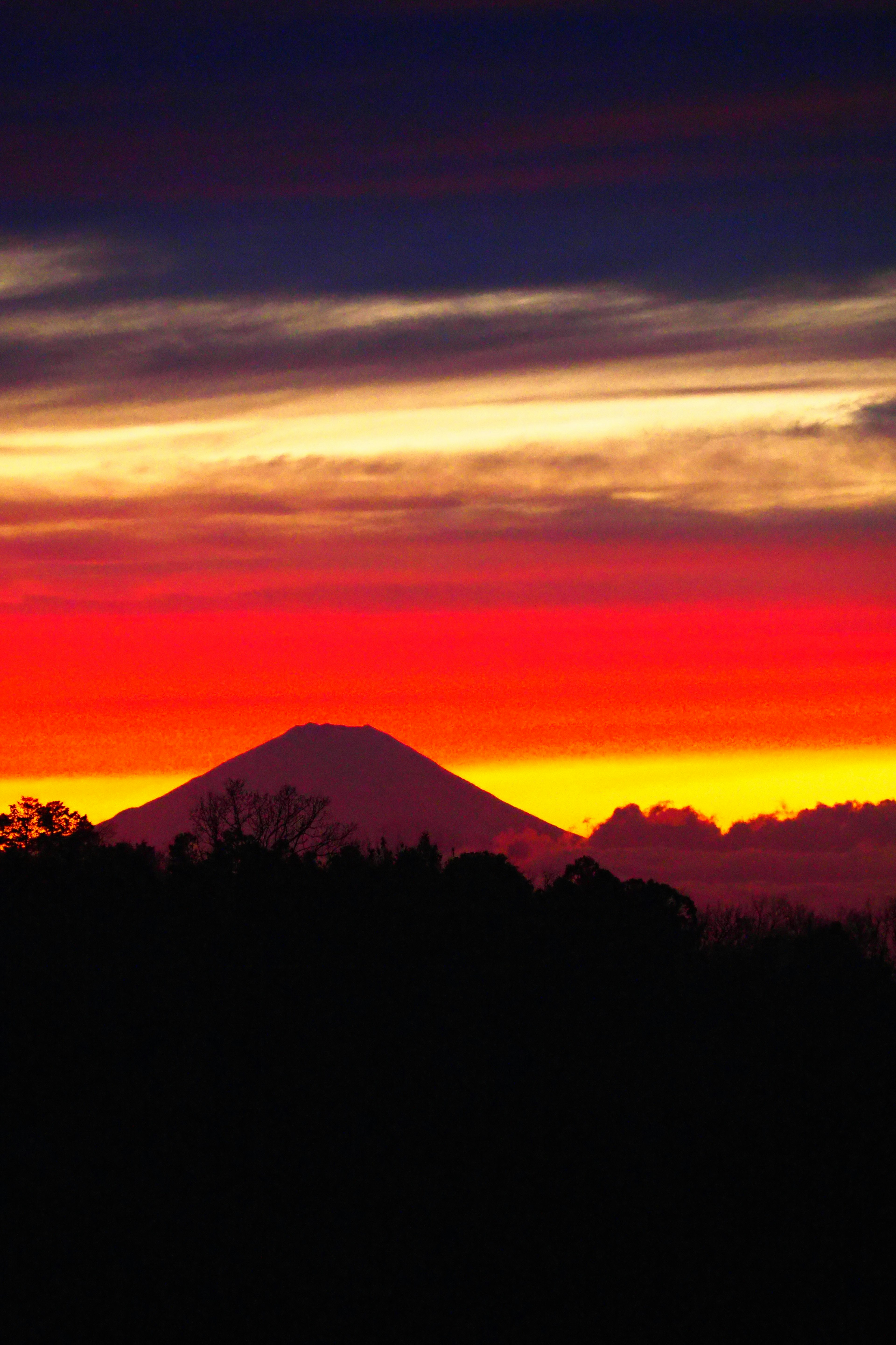 Pemandangan matahari terbenam yang menakjubkan dengan gunung siluet