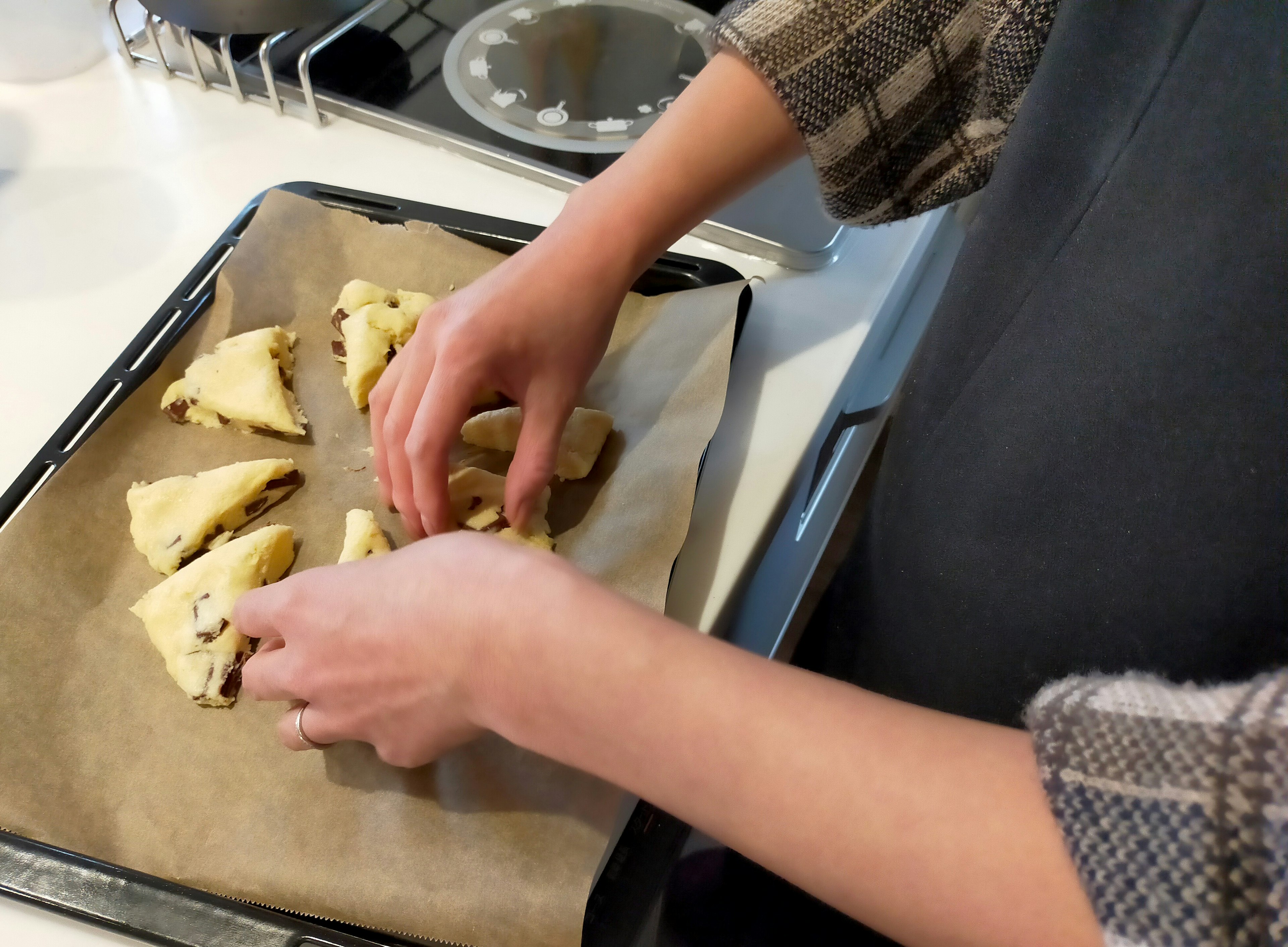 Arranging unbaked pastries on a baking tray