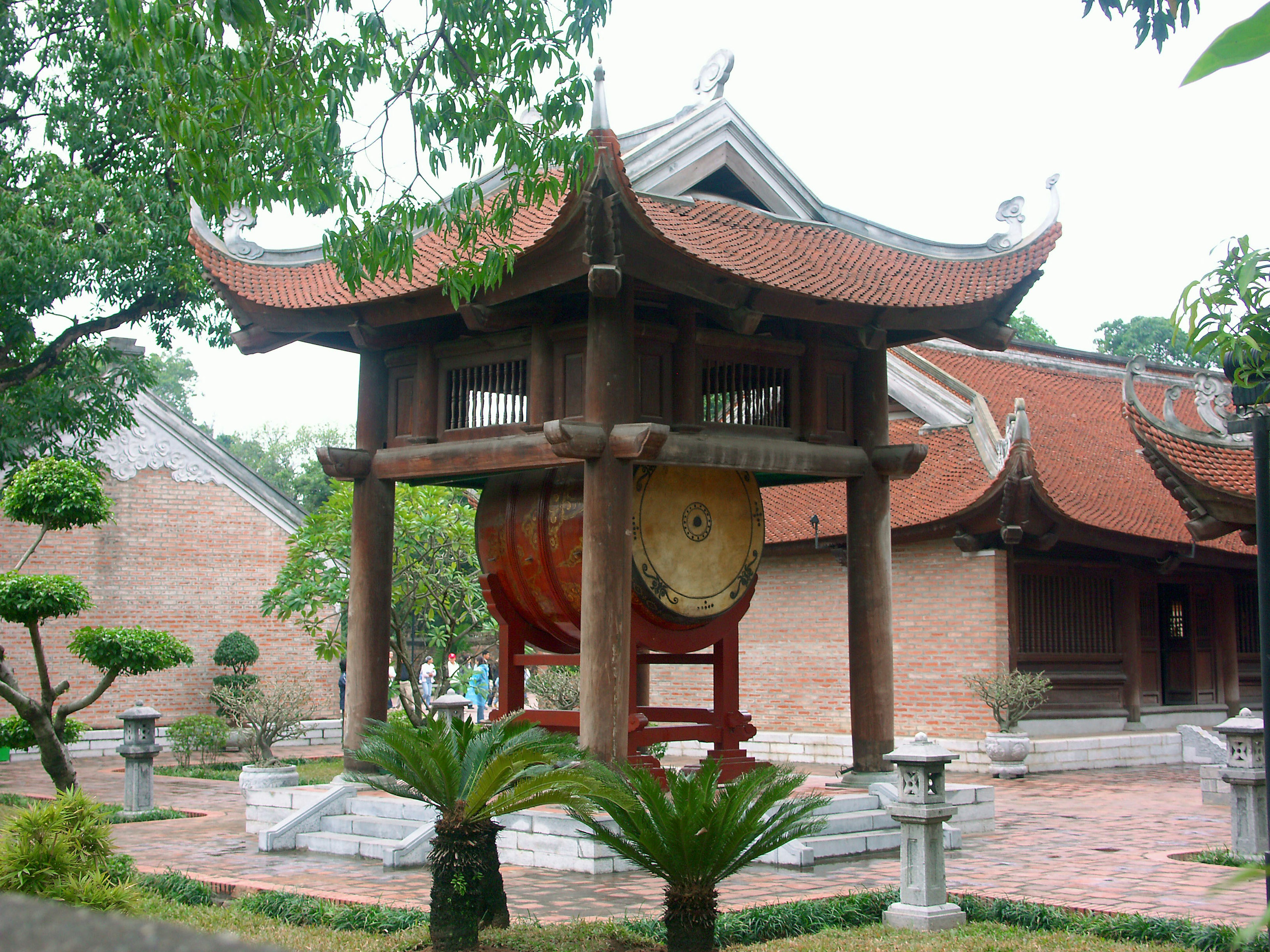 Traditional Vietnamese architecture with a large gong in a serene garden