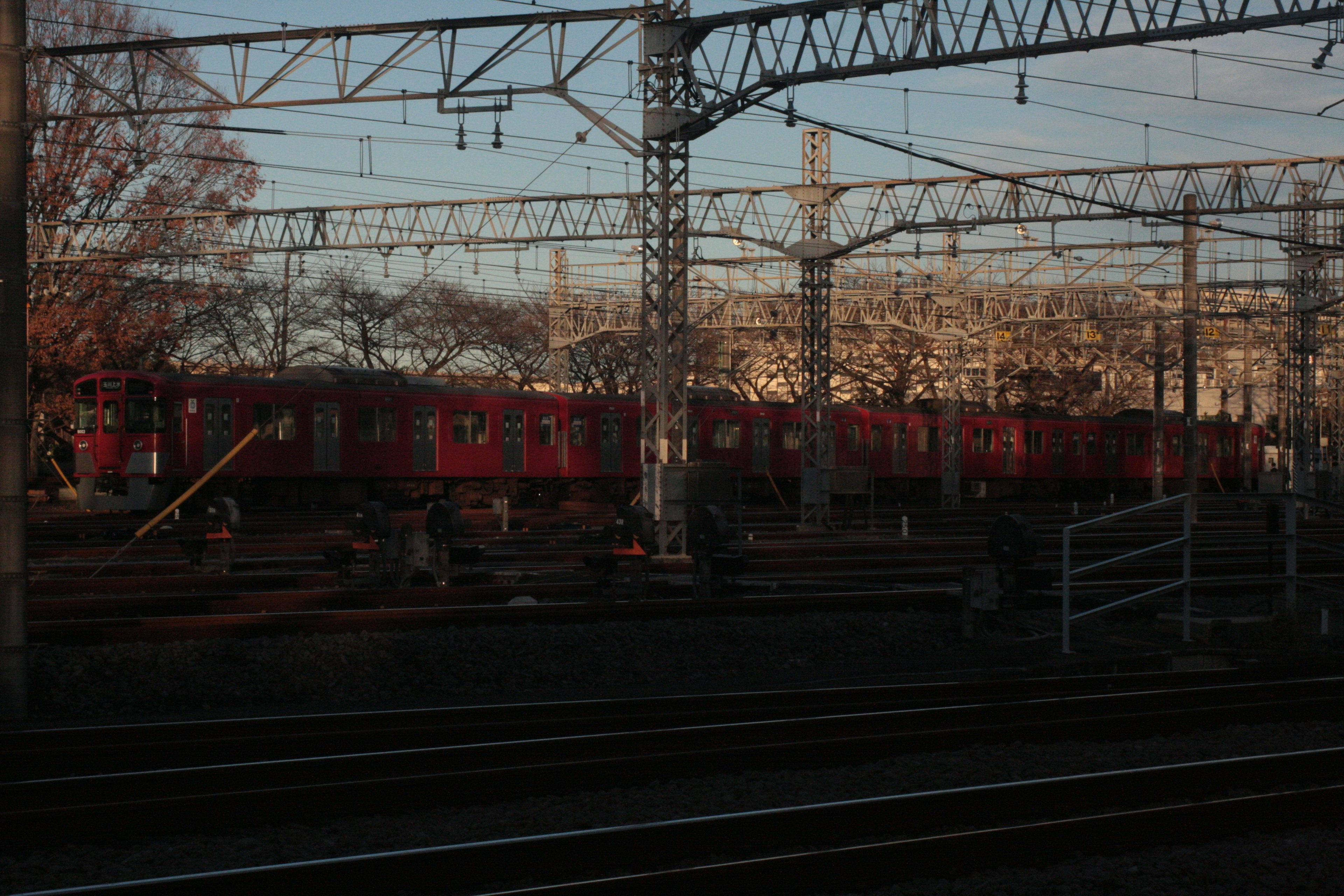 ภาพทิวทัศน์ที่มีรถไฟสีแดงบนรางรถไฟ