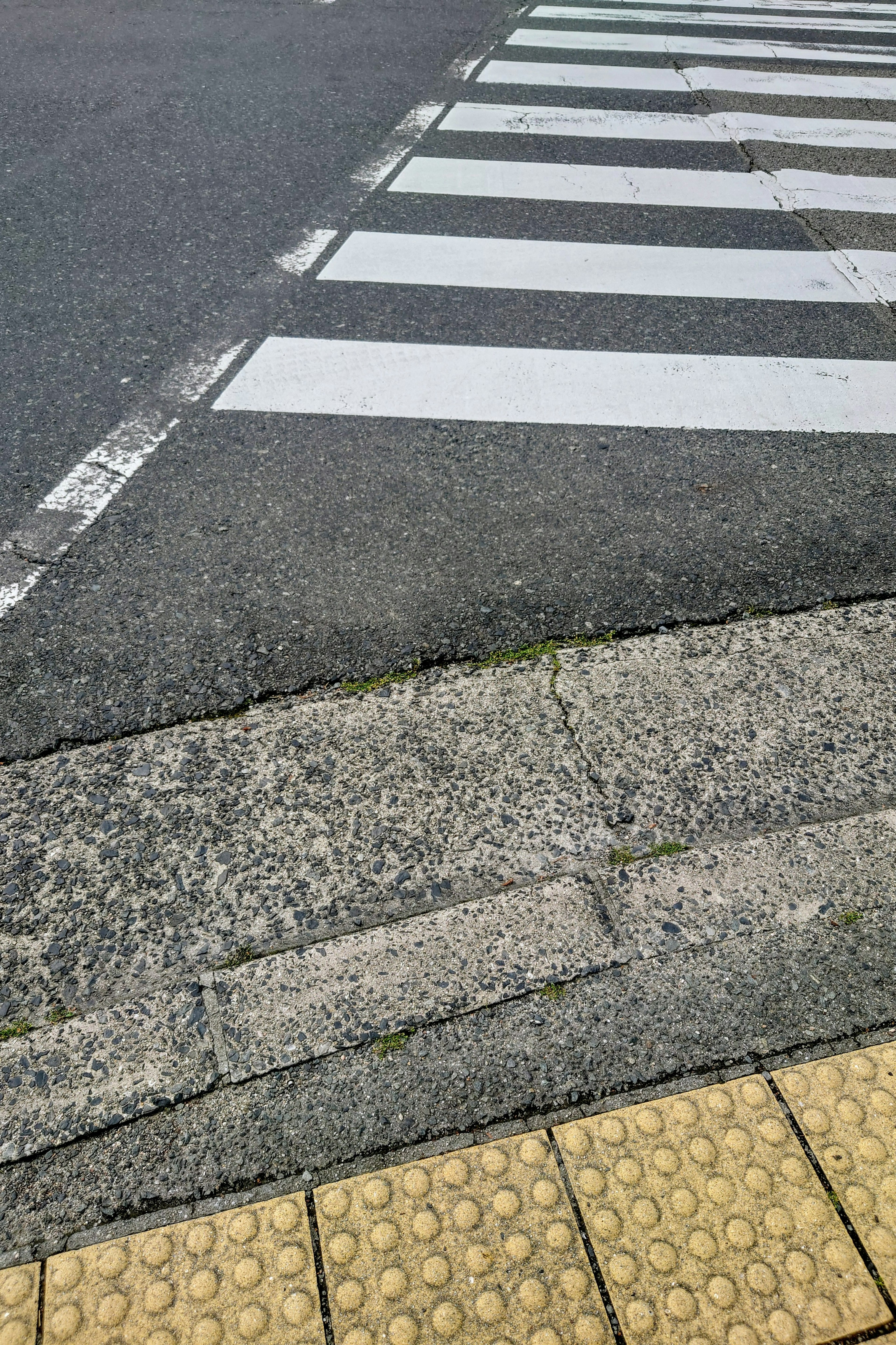 Intersection of white crosswalk and paved road