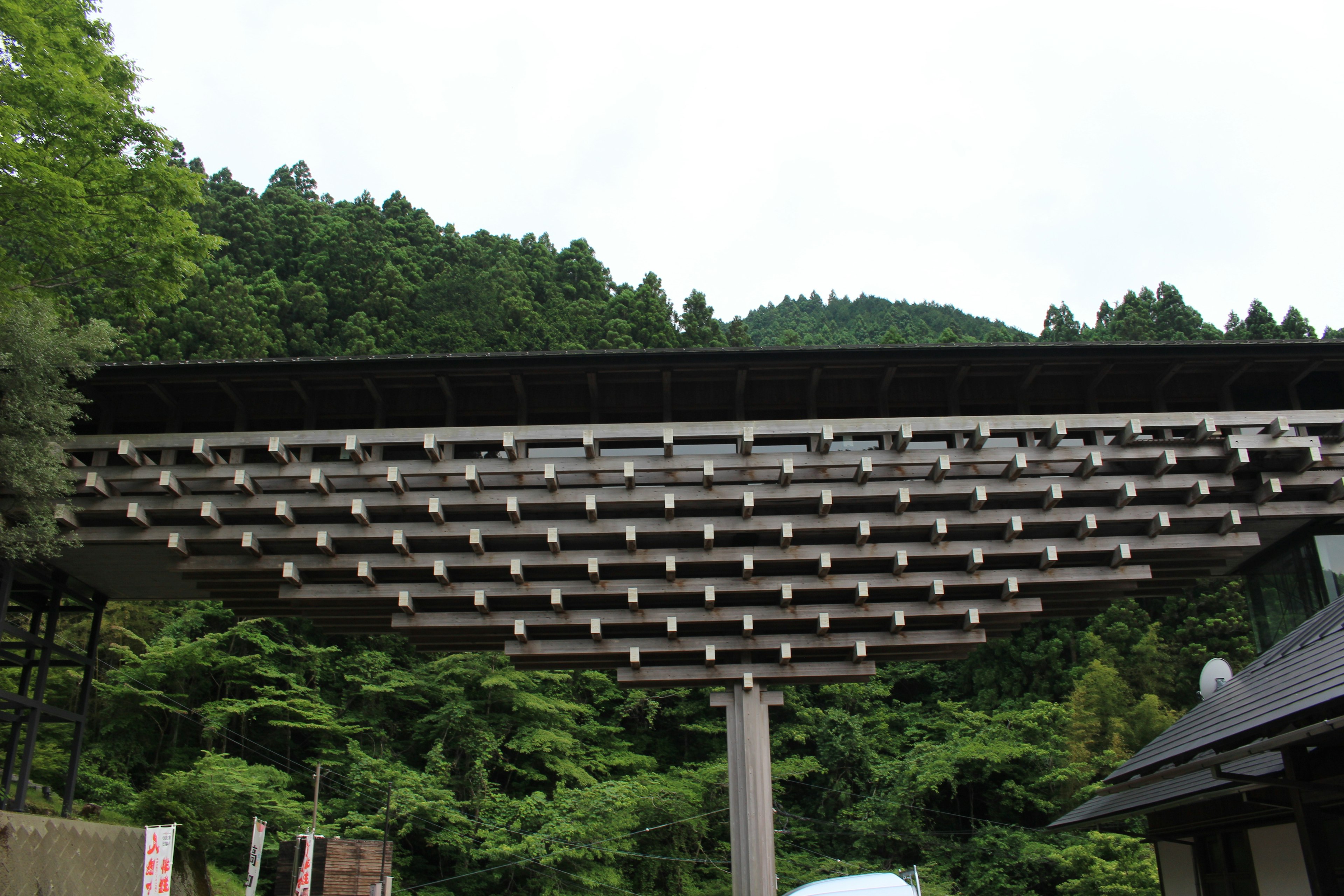 山々に囲まれた現代的な建物の印象的な屋根構造