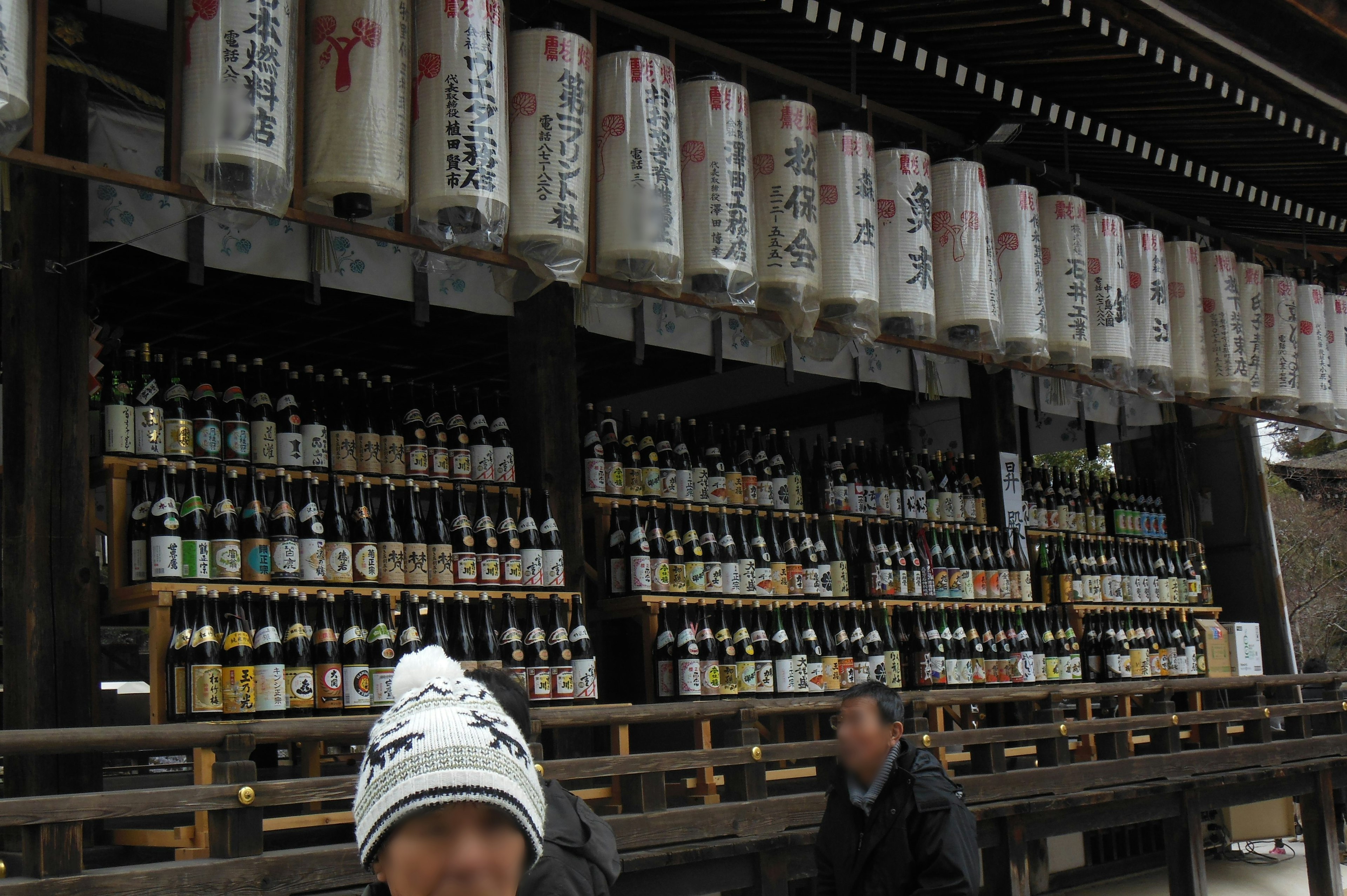 Boutique de sake japonaise traditionnelle avec des rangées de bouteilles de sake et des lanternes