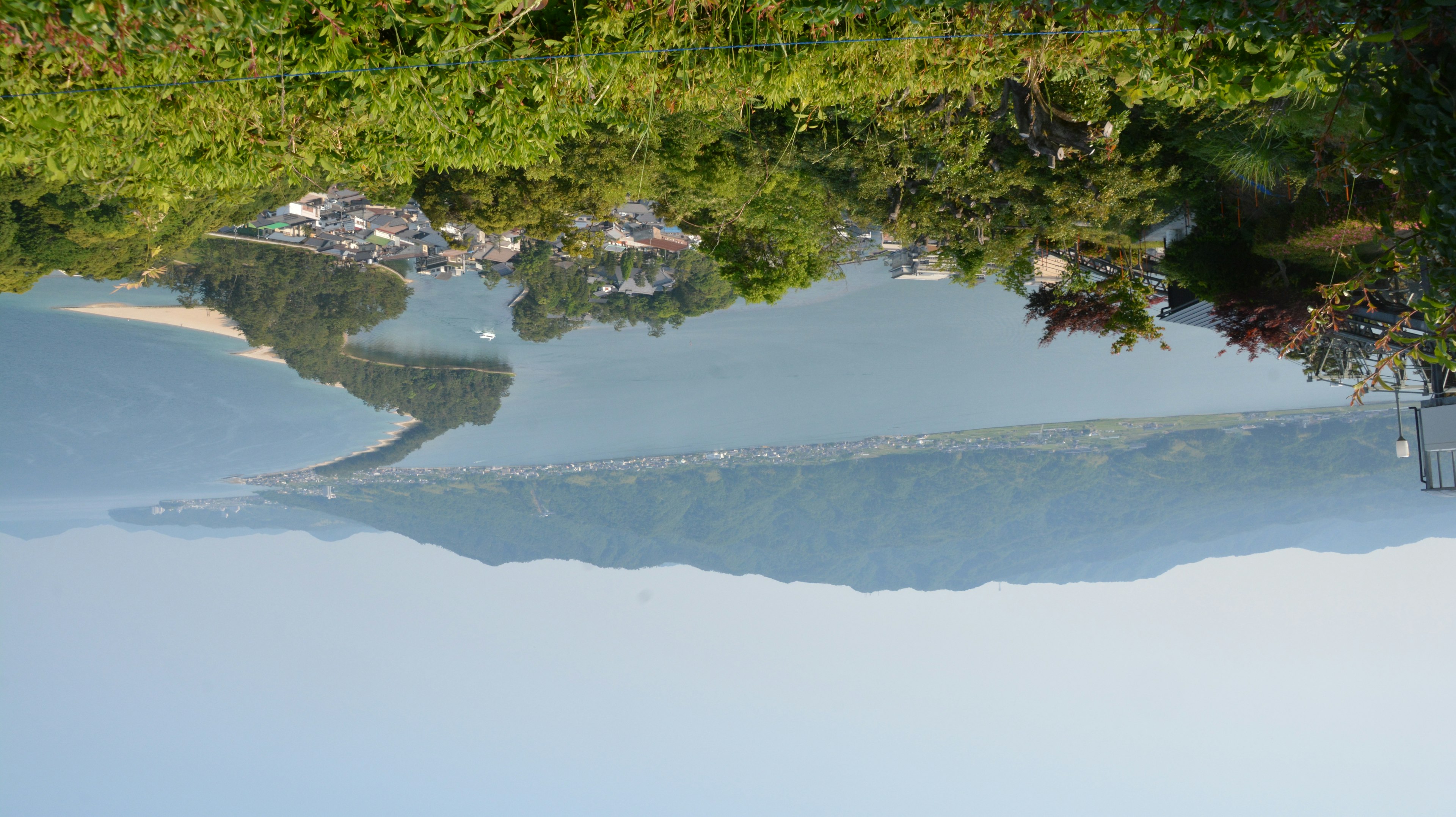 Malersicher Blick auf einen Fluss, umgeben von grünen Hügeln und blauem Wasser