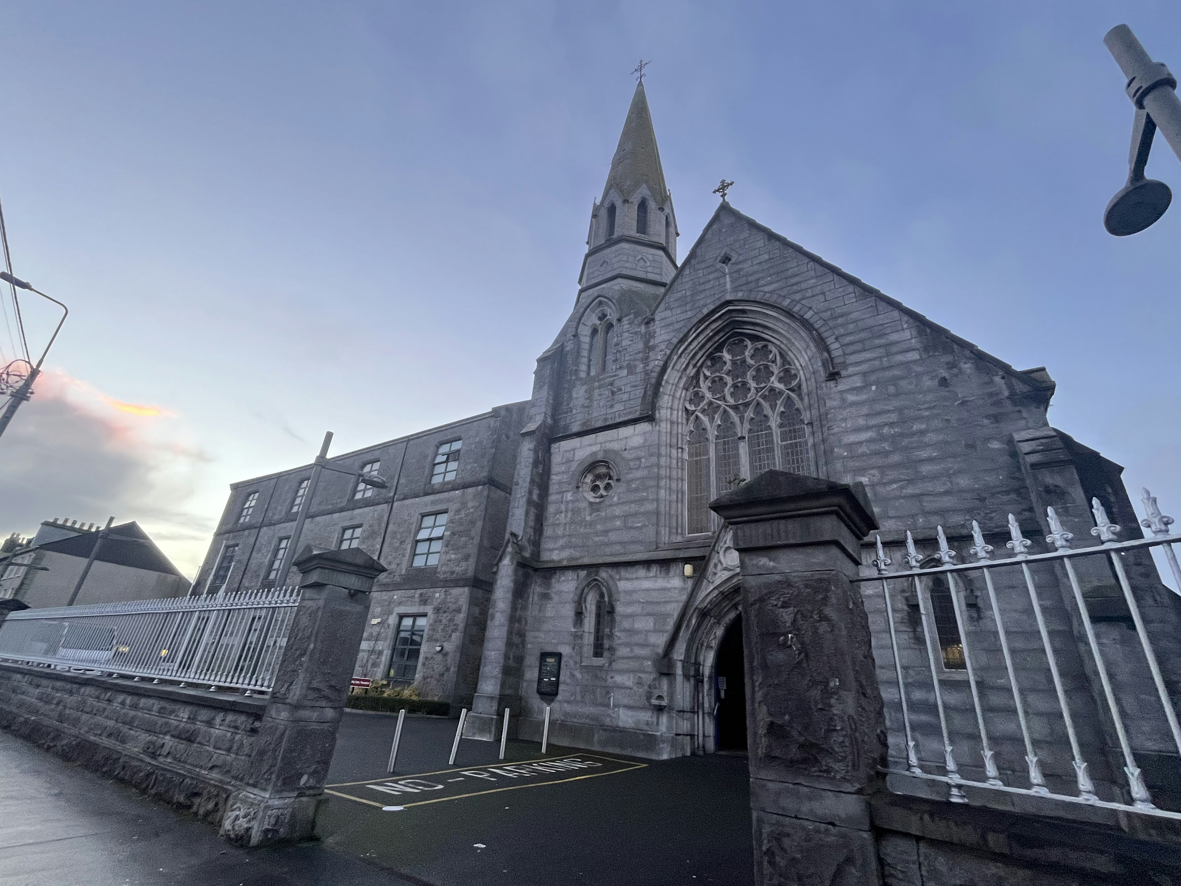 Stone church exterior with prominent spire and gothic architecture