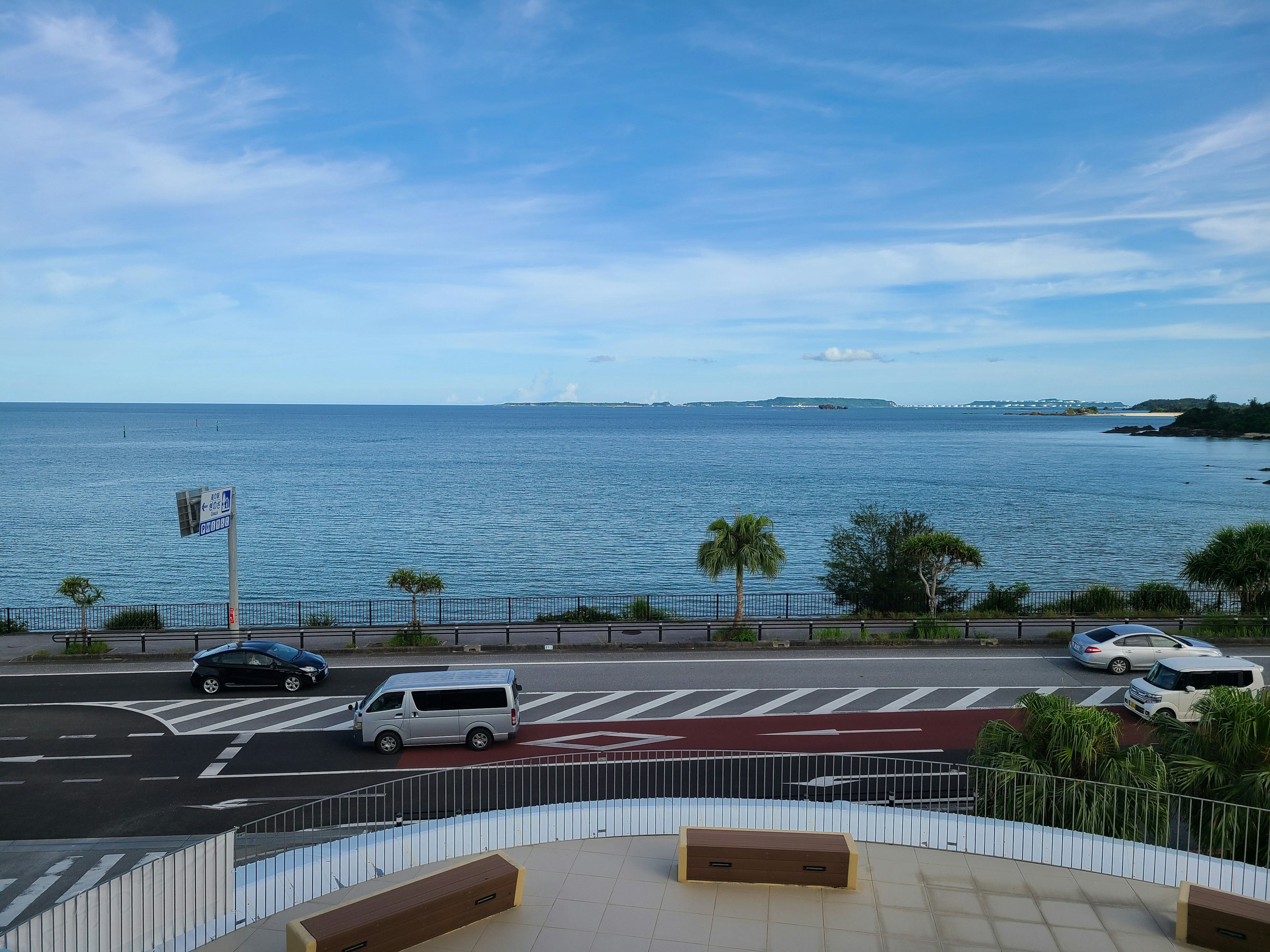 Scenic view of blue sea and sky with visible road