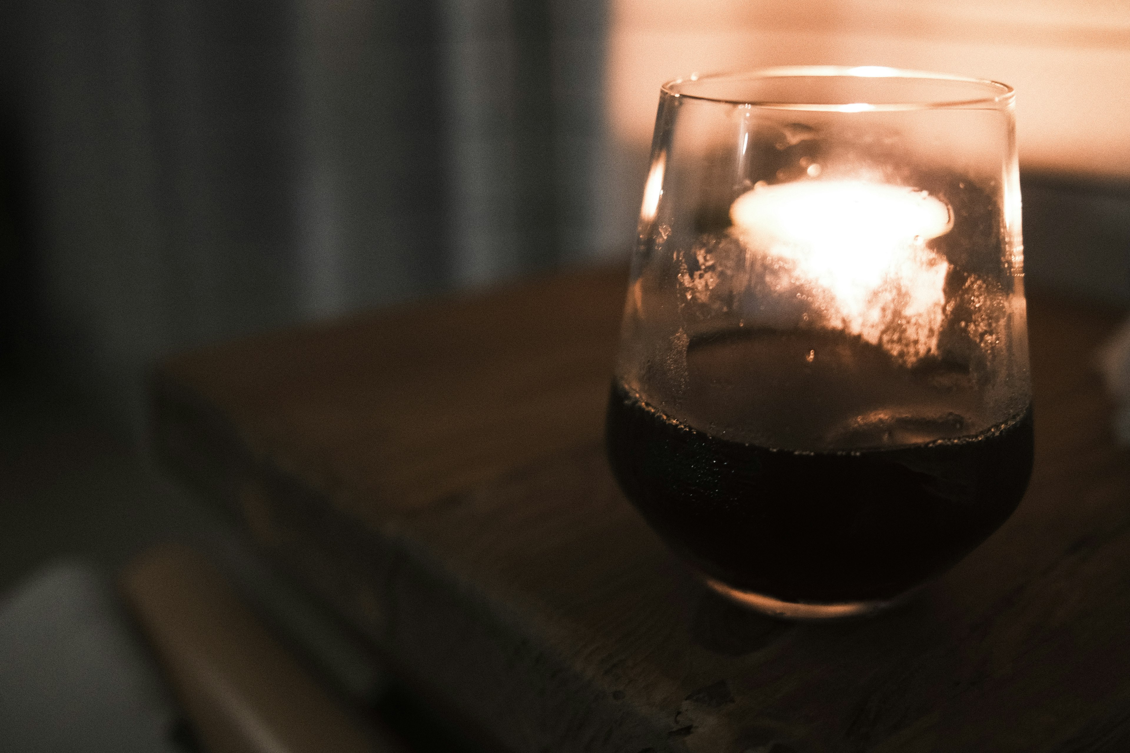 Close-up of a glass with a lit candle Warm light illuminating the surroundings