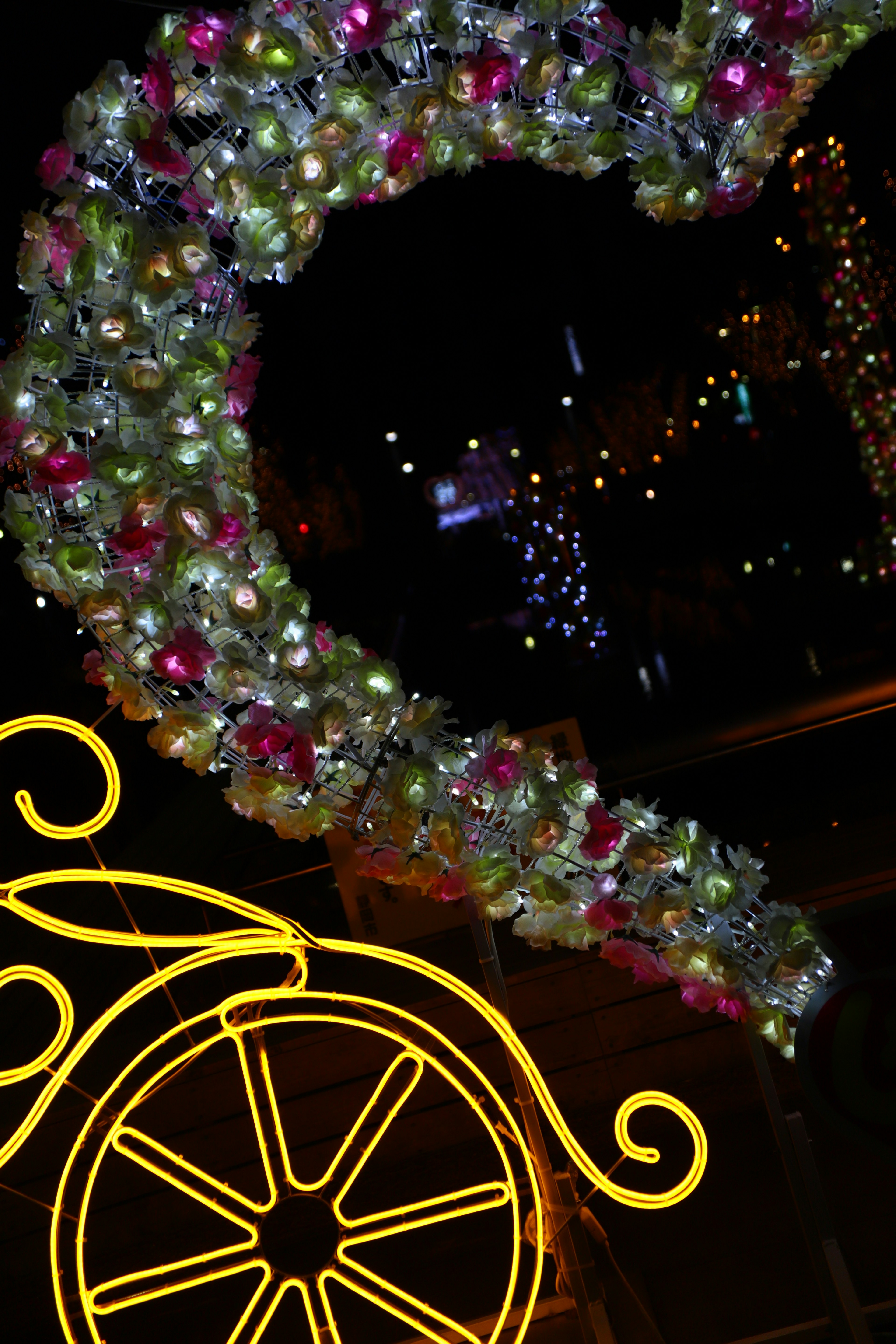 Decorative floral wreath and bright yellow wheel design at night