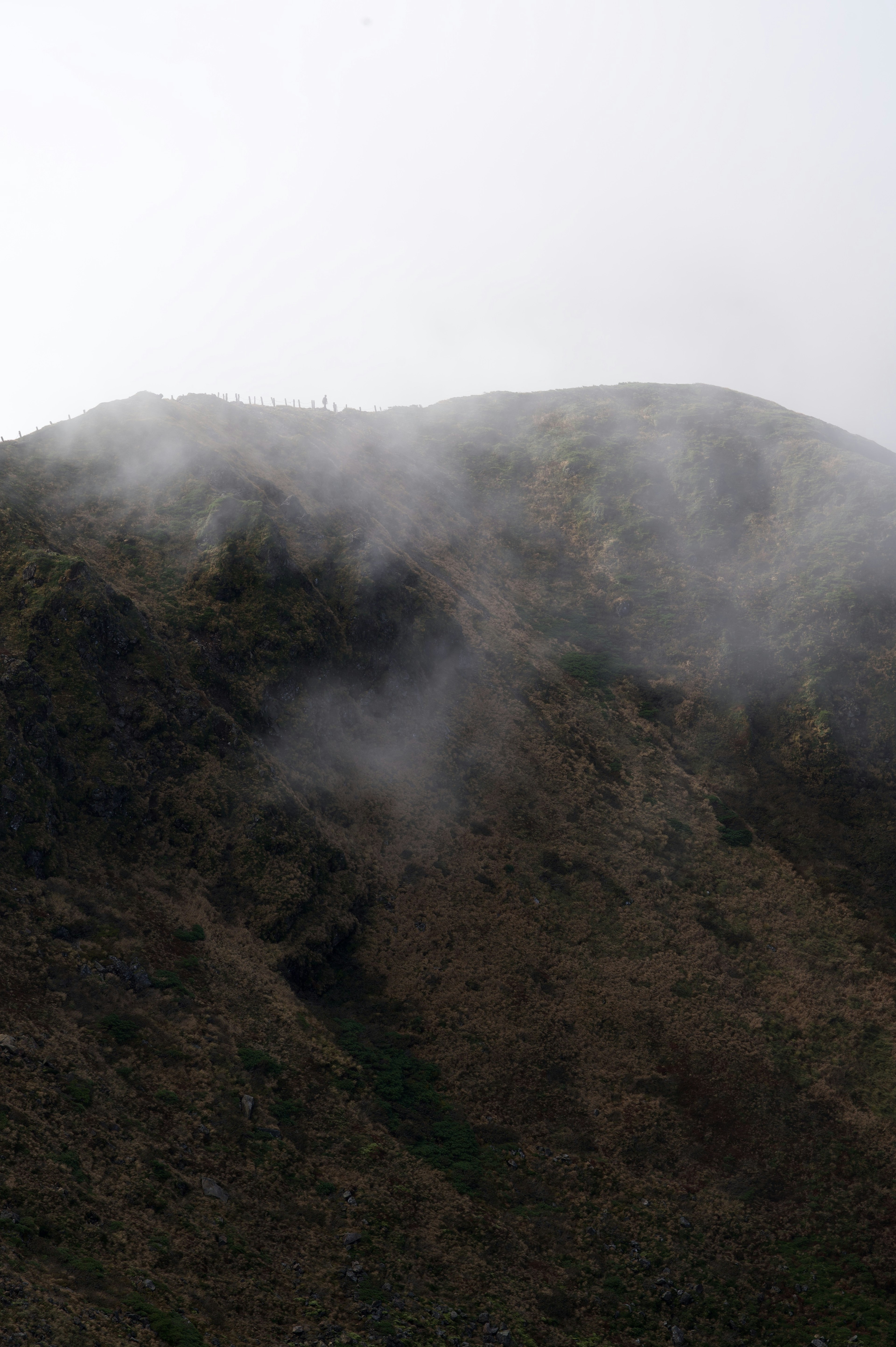 霧がかかった山の風景　土の色が目立つ