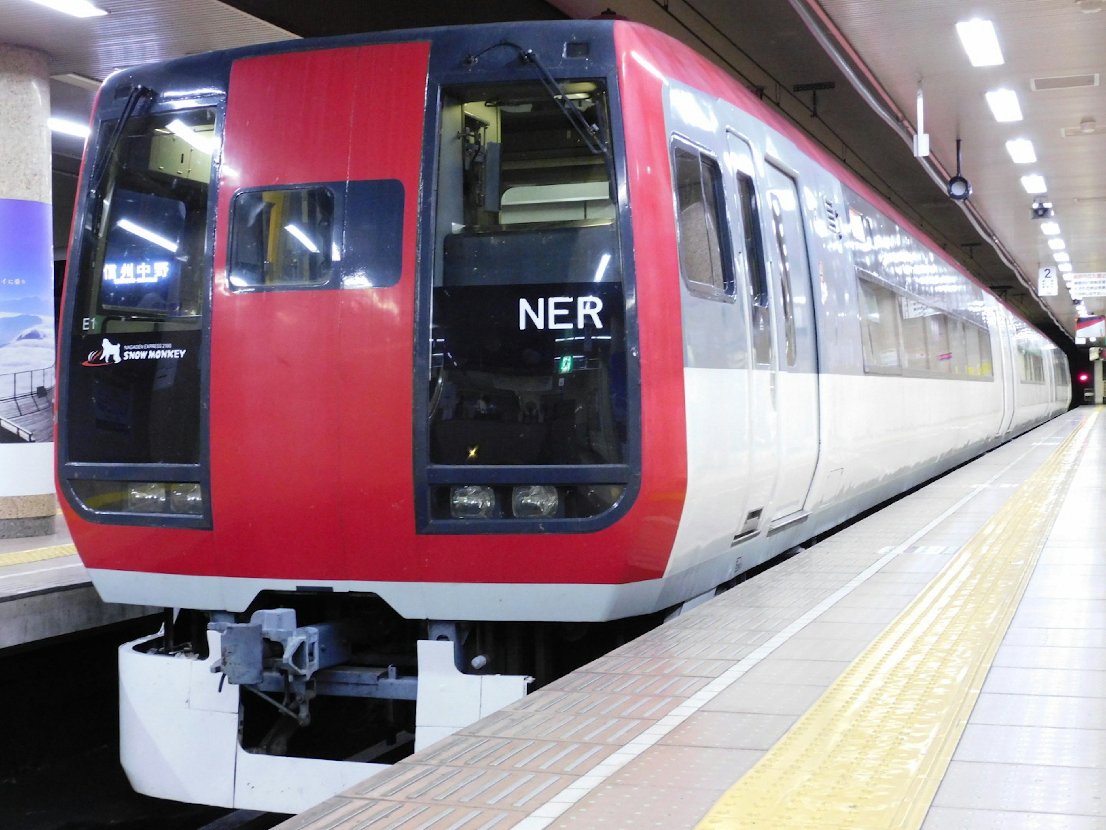 Kereta merah dan putih berhenti di stasiun