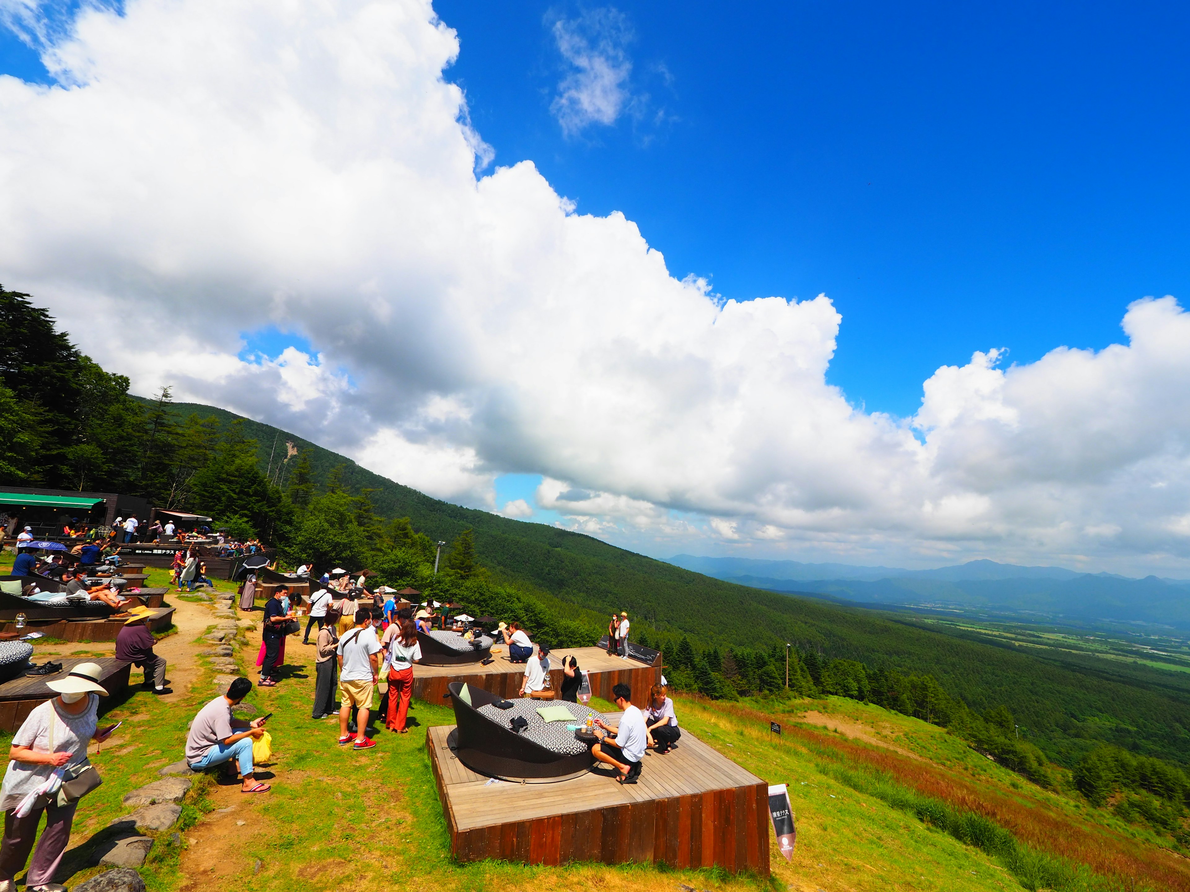 People enjoying the mountain view under a blue sky with white clouds