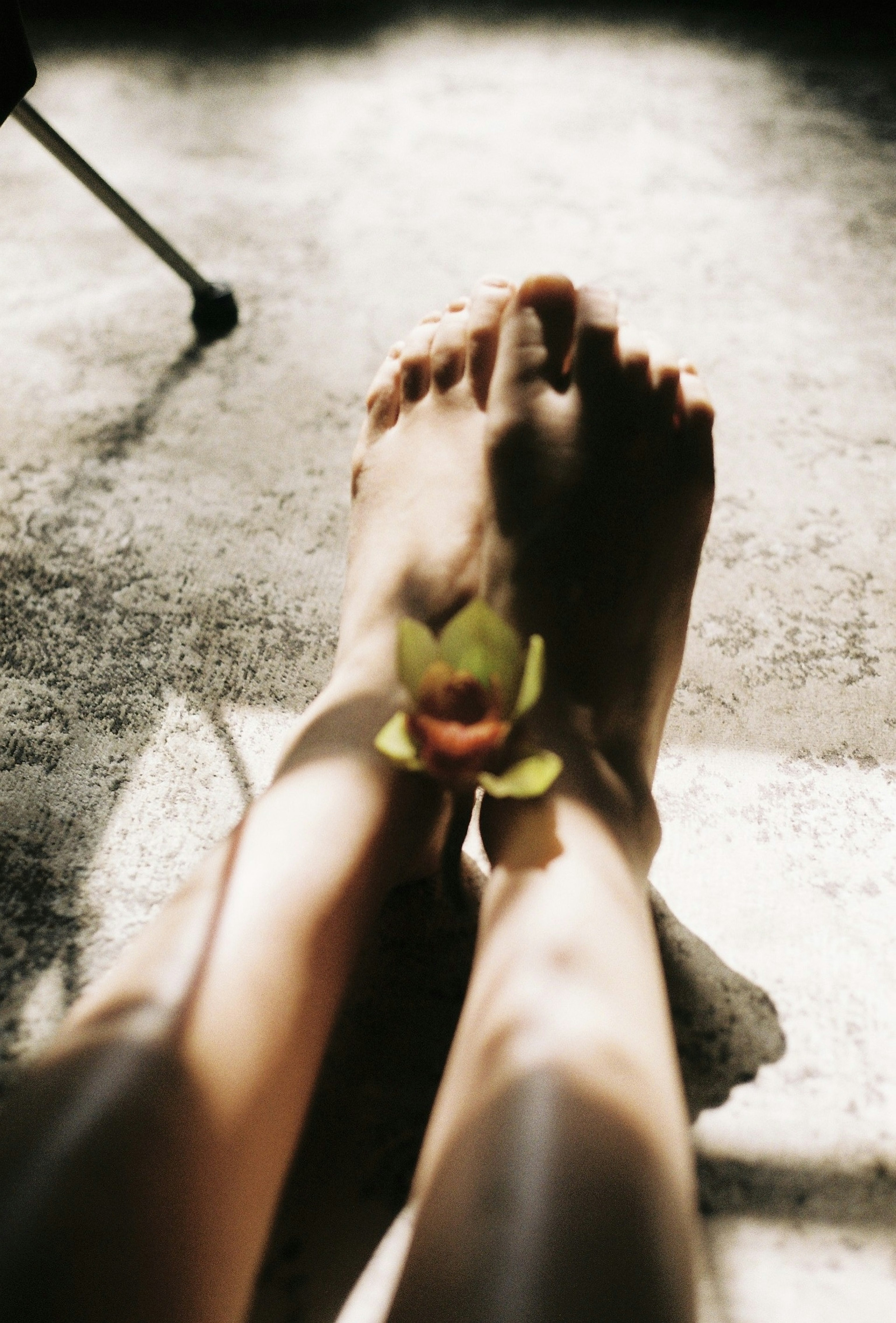 Foto de pies con una flor colocada en el tobillo