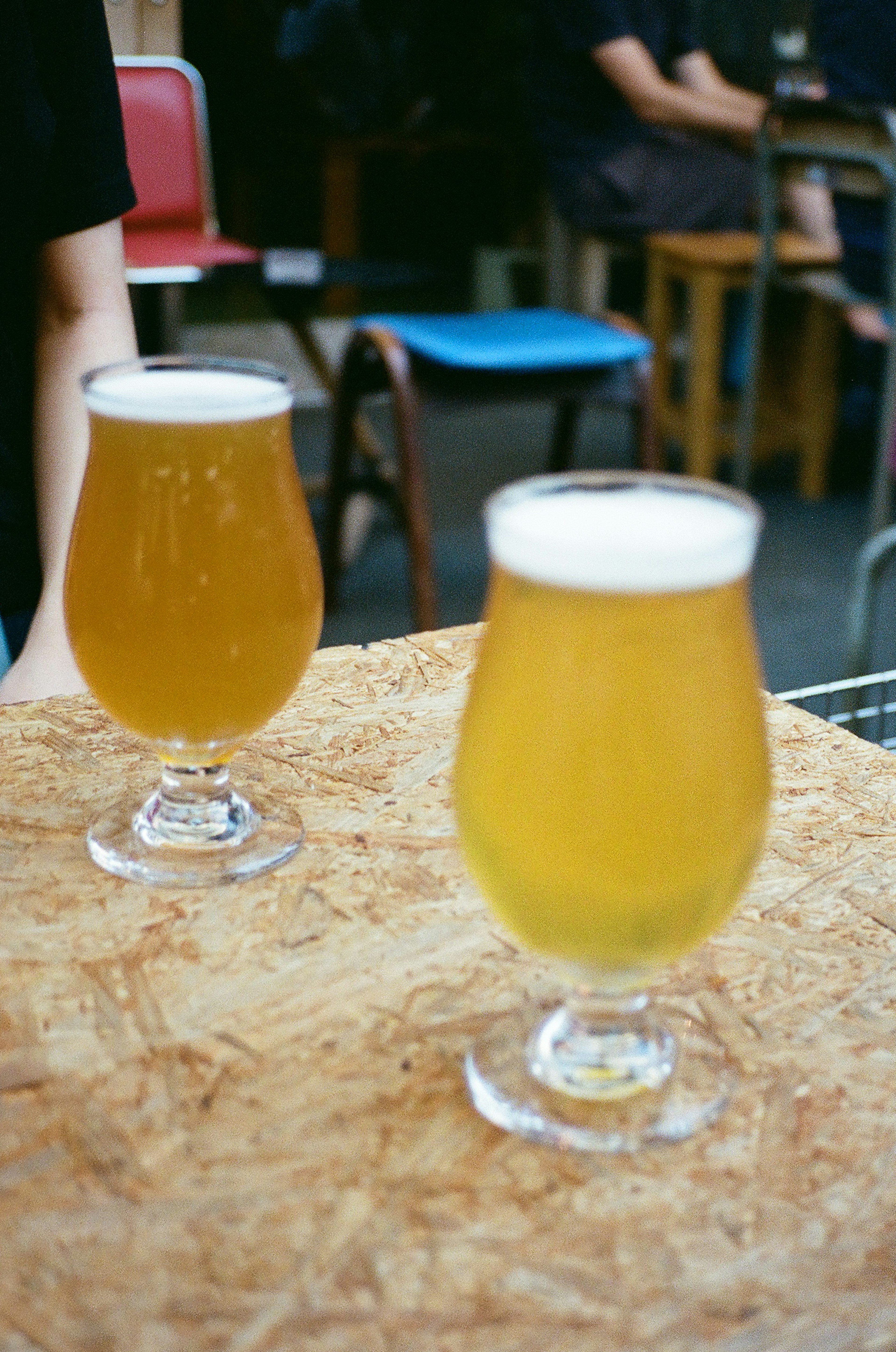 Dos vasos de cerveza sobre una mesa de madera