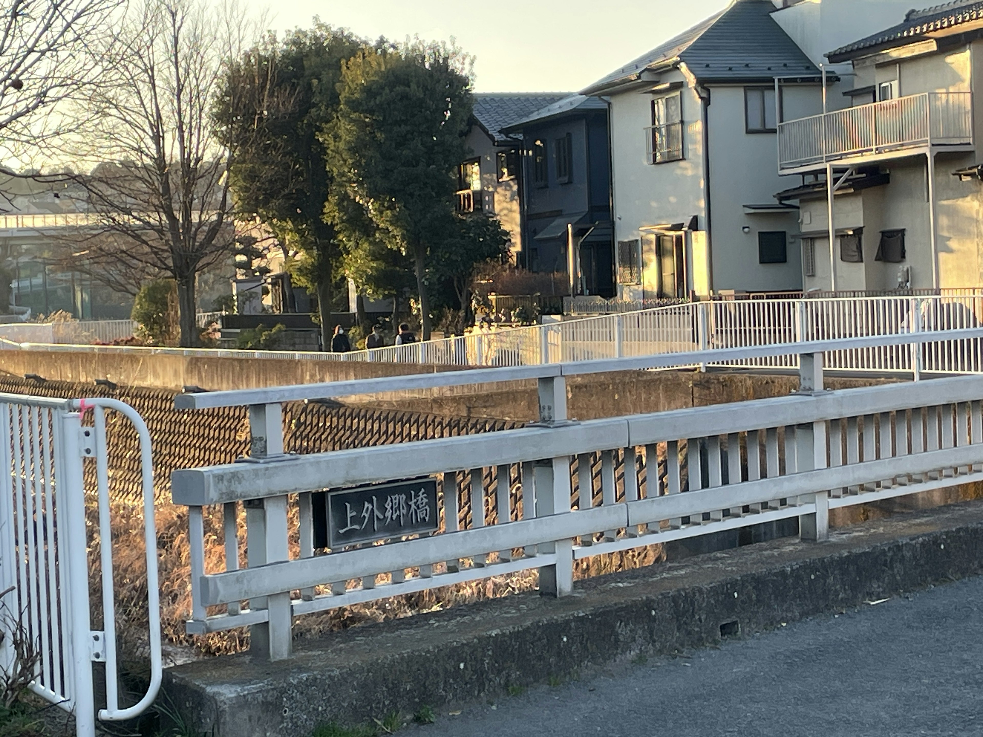 Pont à clôture blanche dans un quartier résidentiel avec des bâtiments environnants