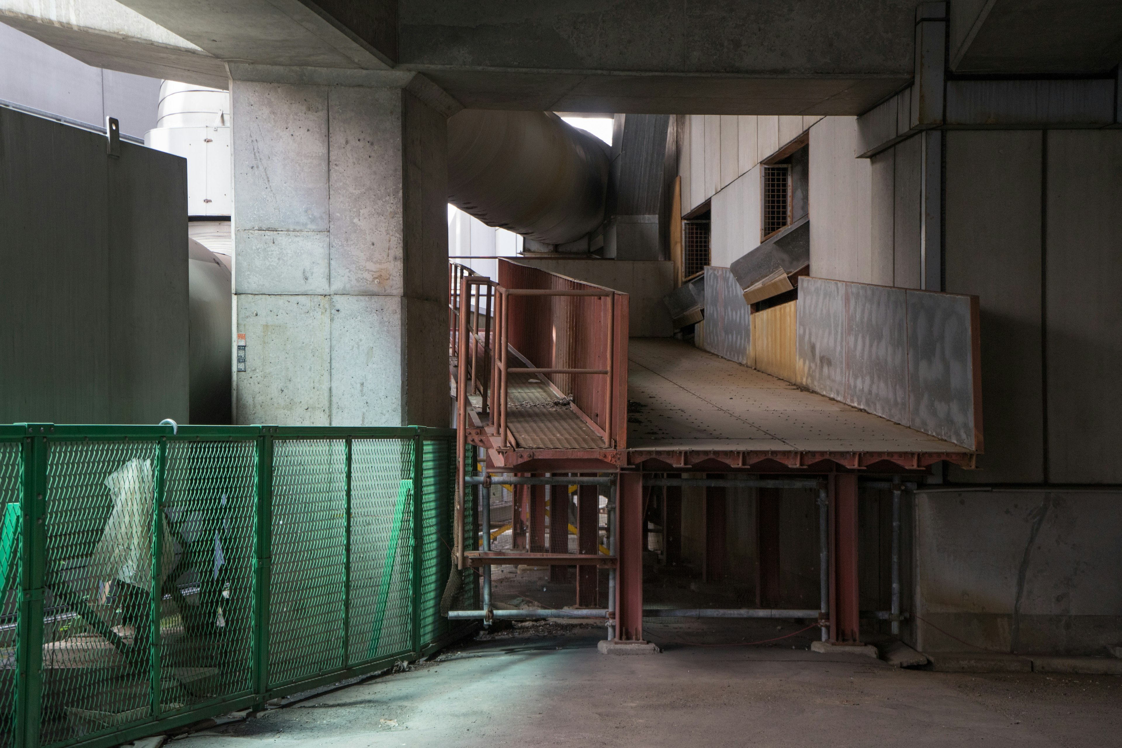 Rampa de construcción entre edificios con cerca verde