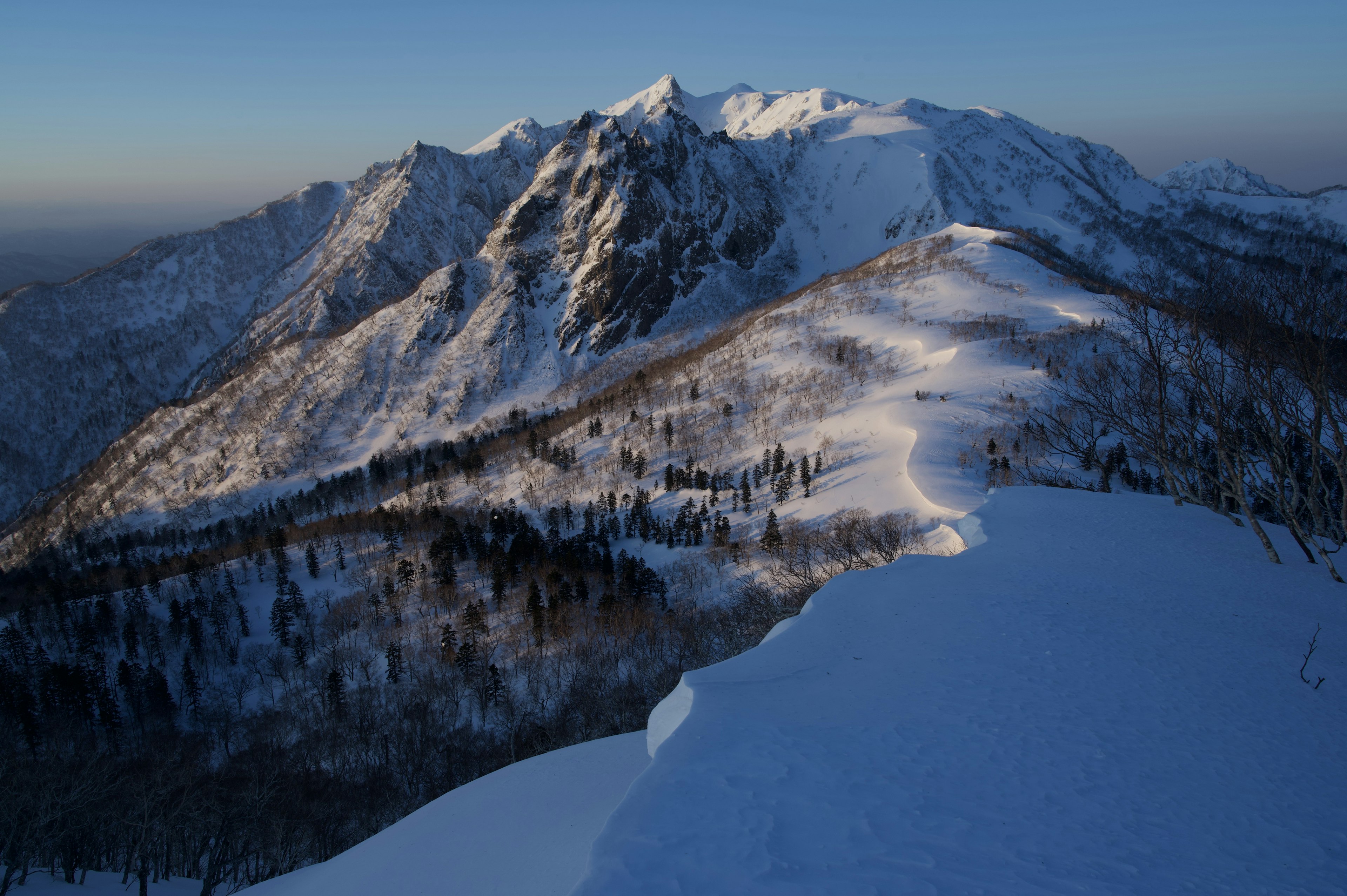 Chaîne de montagnes enneigée sous un ciel bleu clair