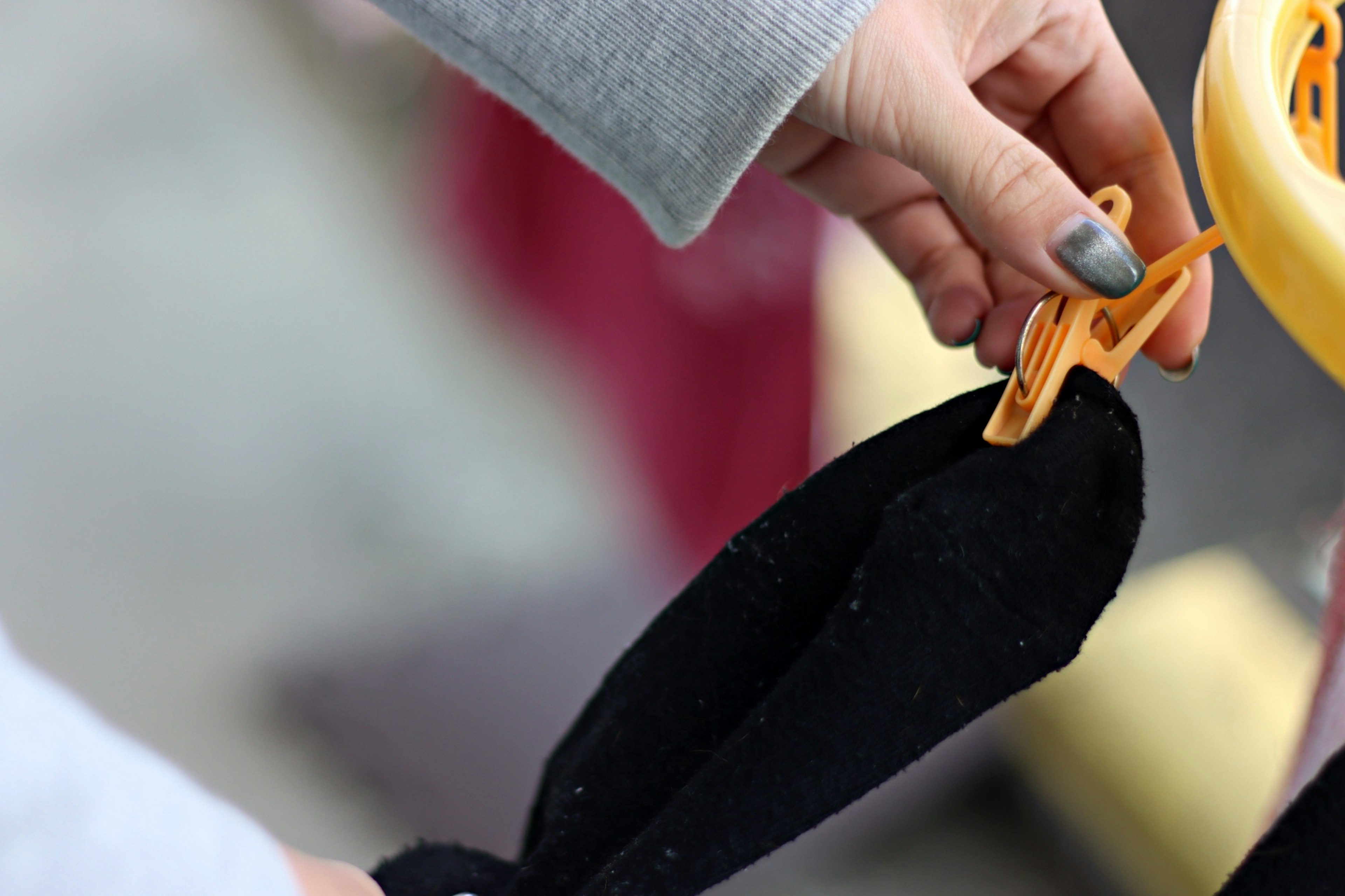 Close-up of a hand holding black fabric secured with a clip