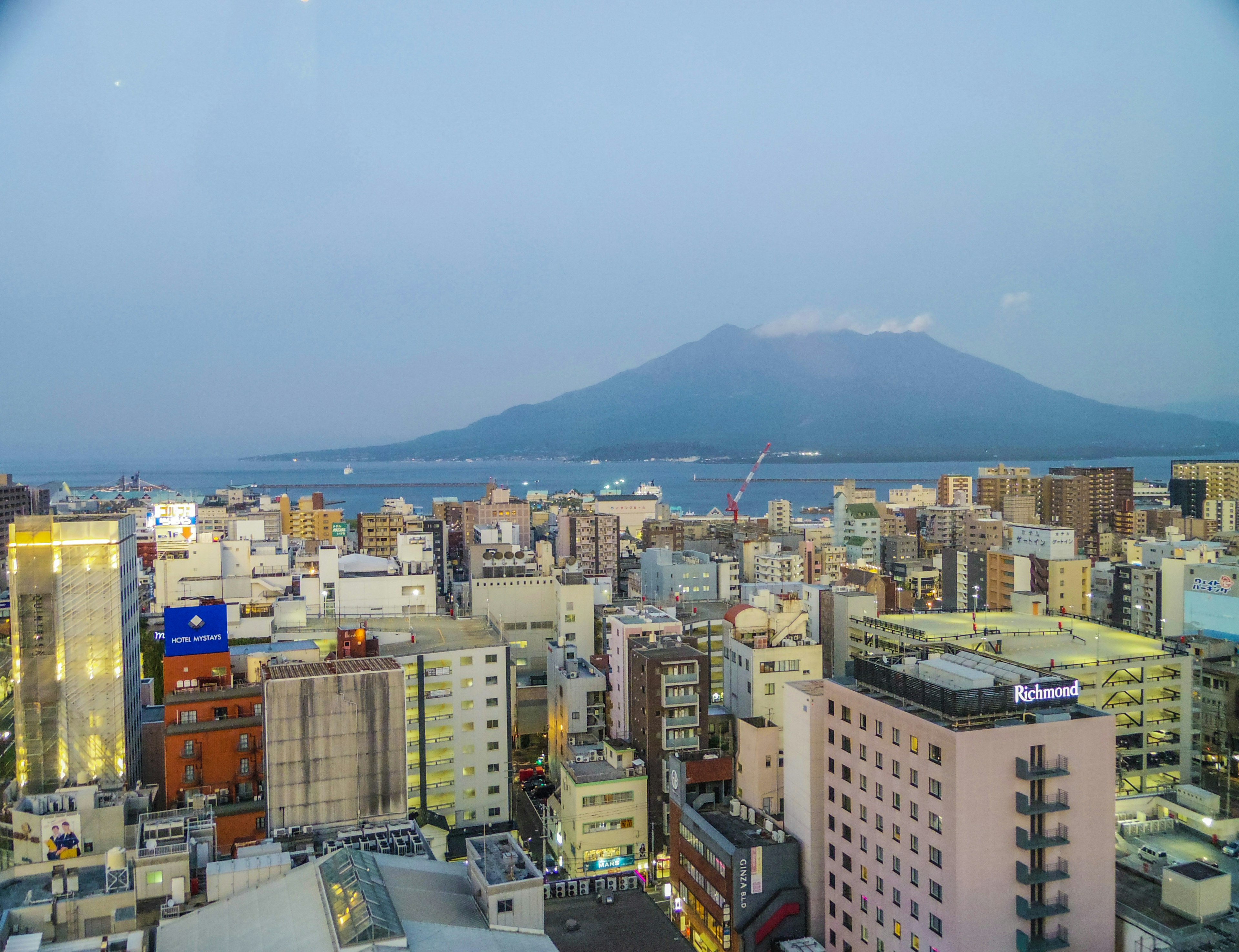 霧の中に浮かぶ桜島と鹿児島市の高層ビル群