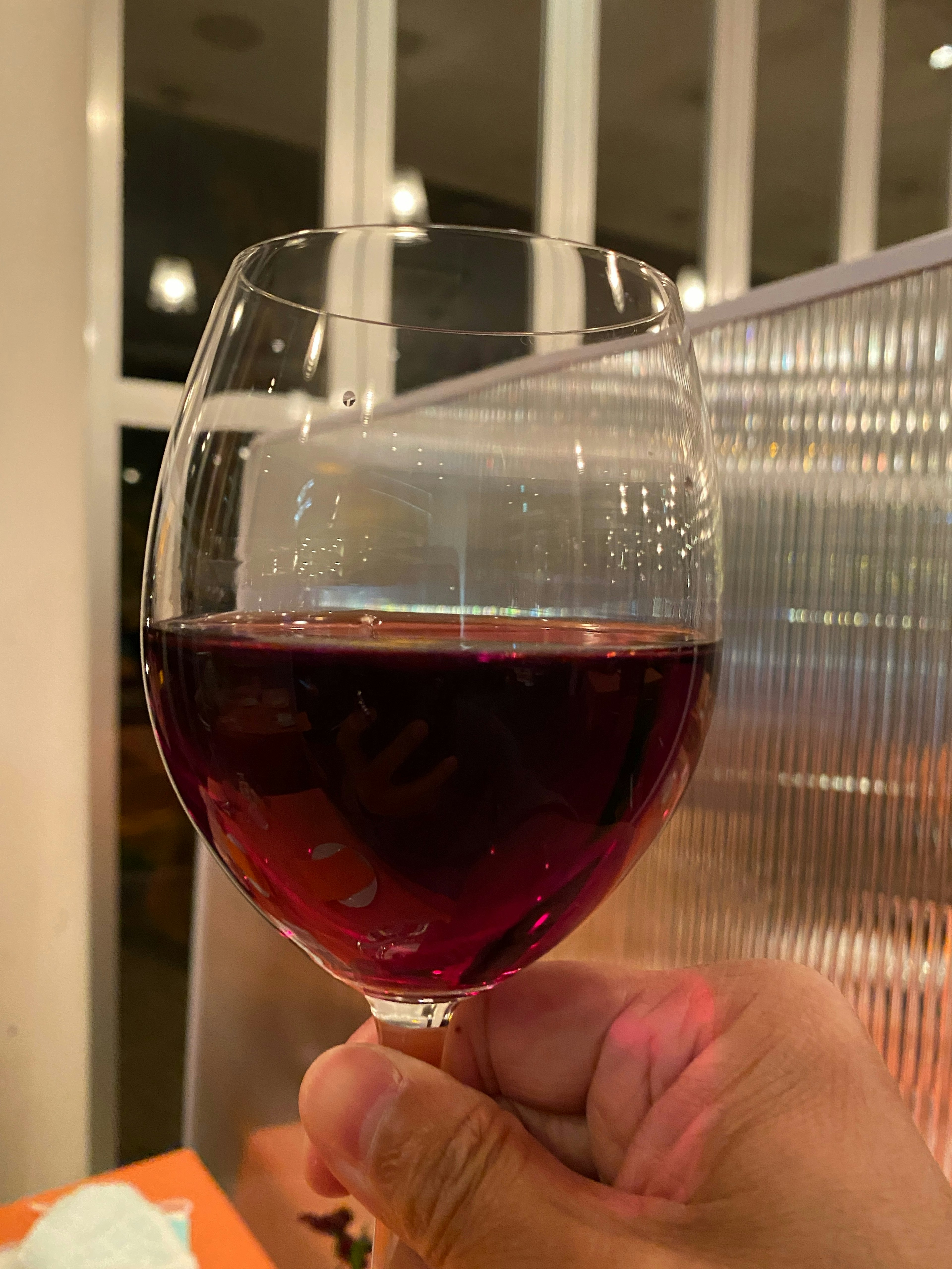 Close-up of a hand holding a glass of red wine