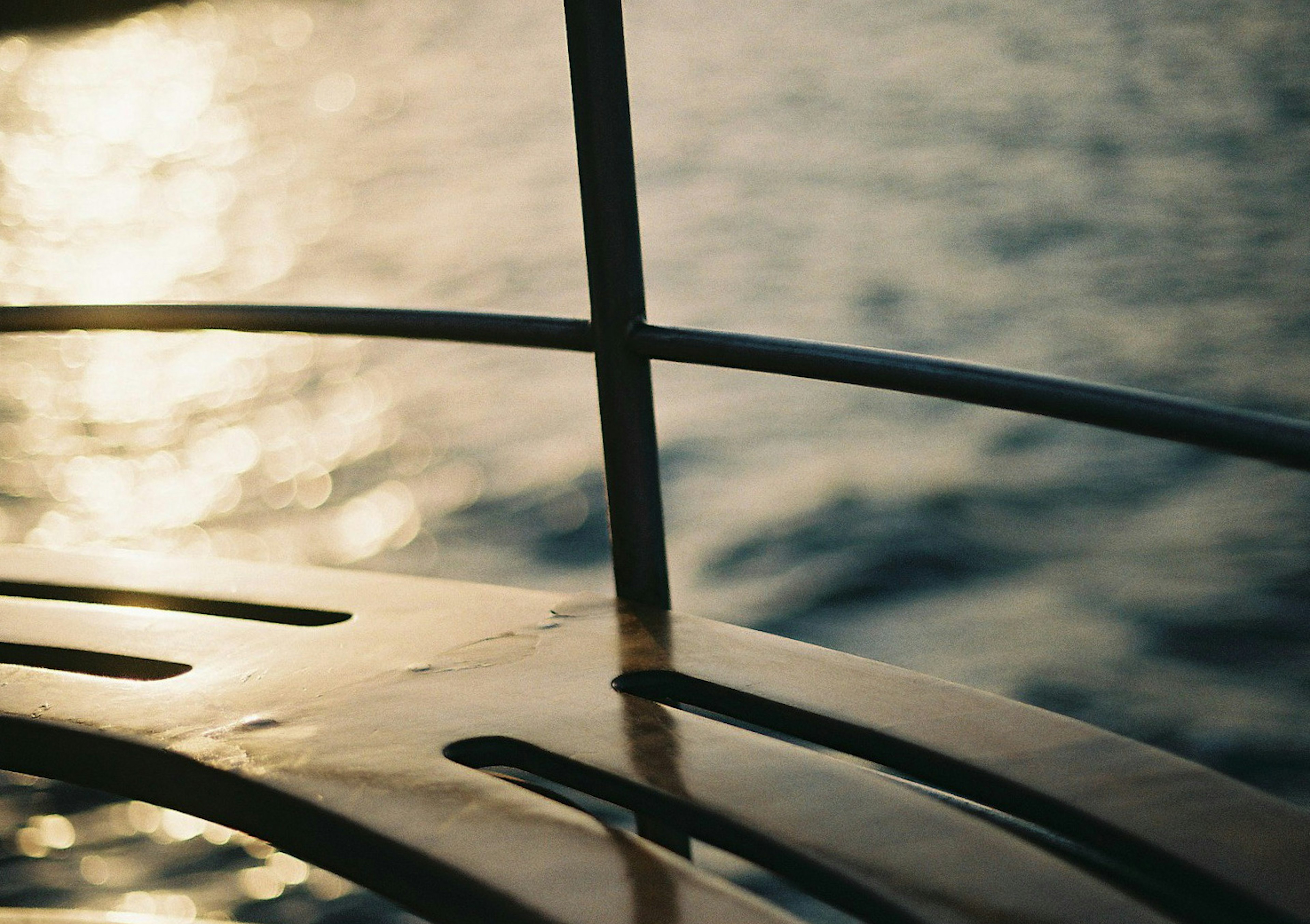 Close-up pagar perahu dengan refleksi di atas air