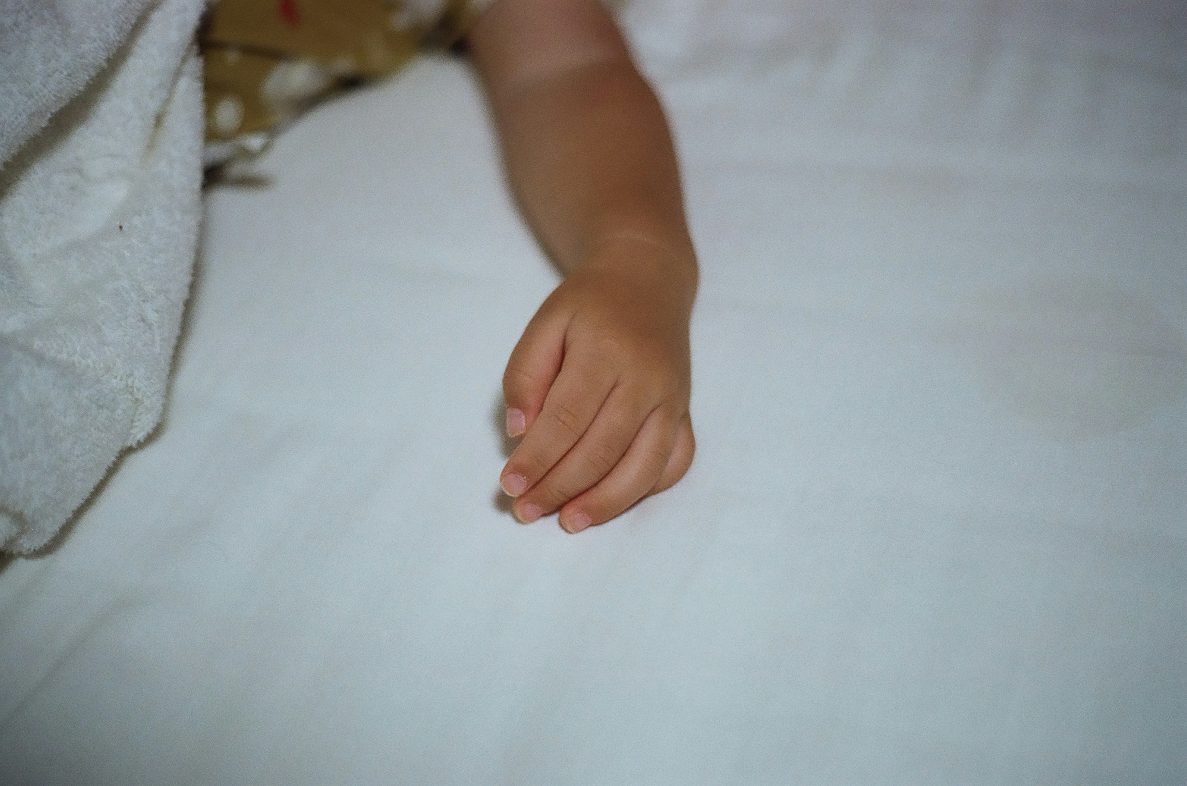 Eine Kinderhand, die auf einem weißen Blatt ruht