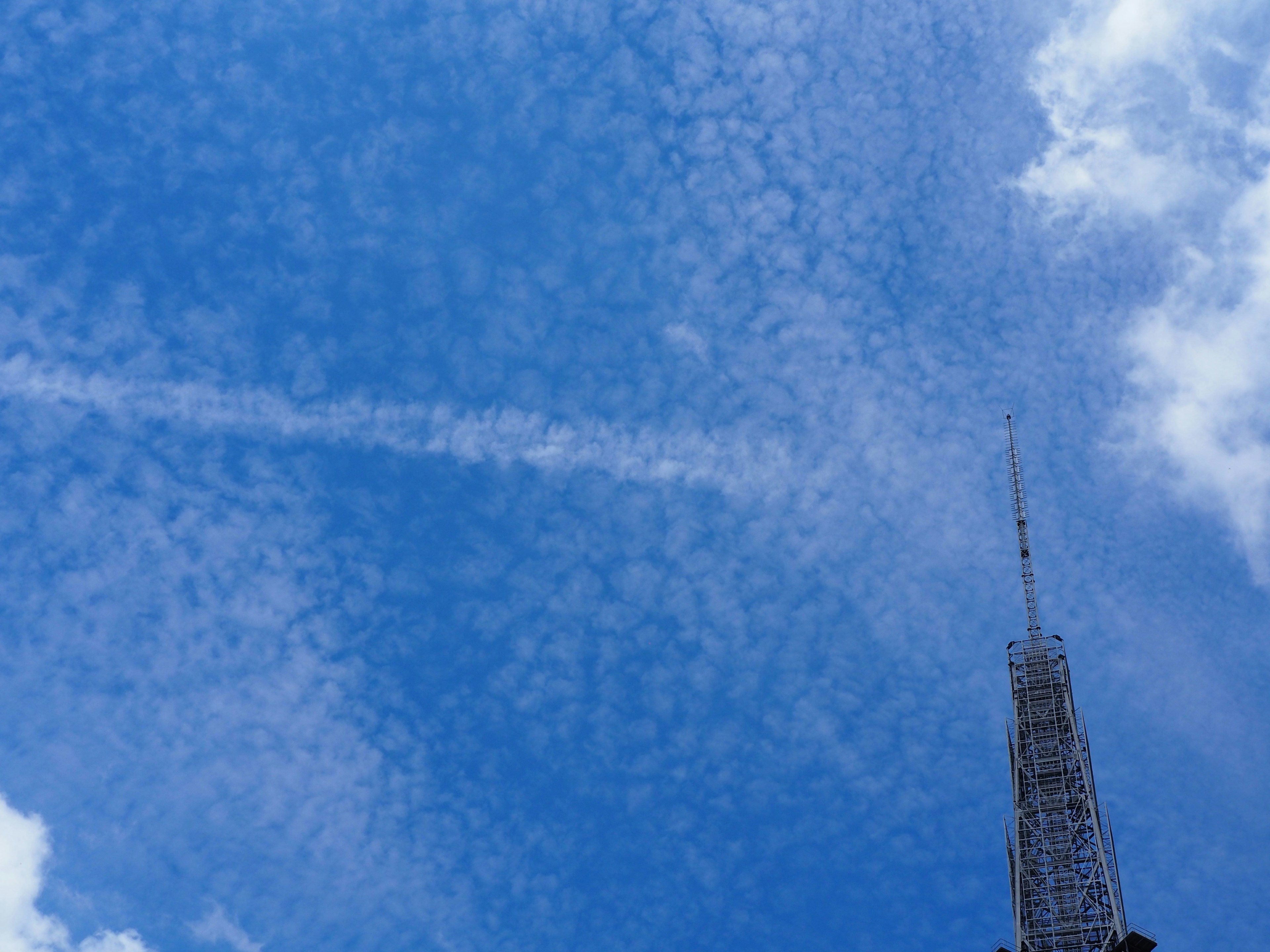 Image of a tall tower against a blue sky filled with clouds