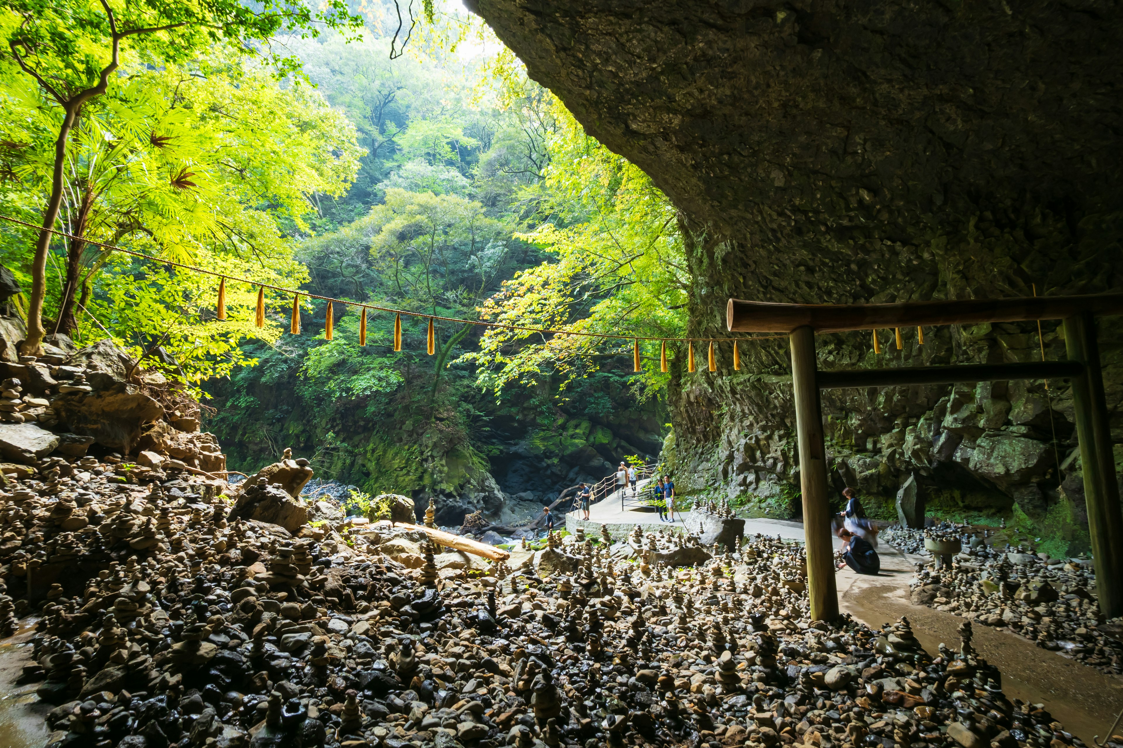 Una vista del interior de una cueva rodeada de vegetación con torres de piedra