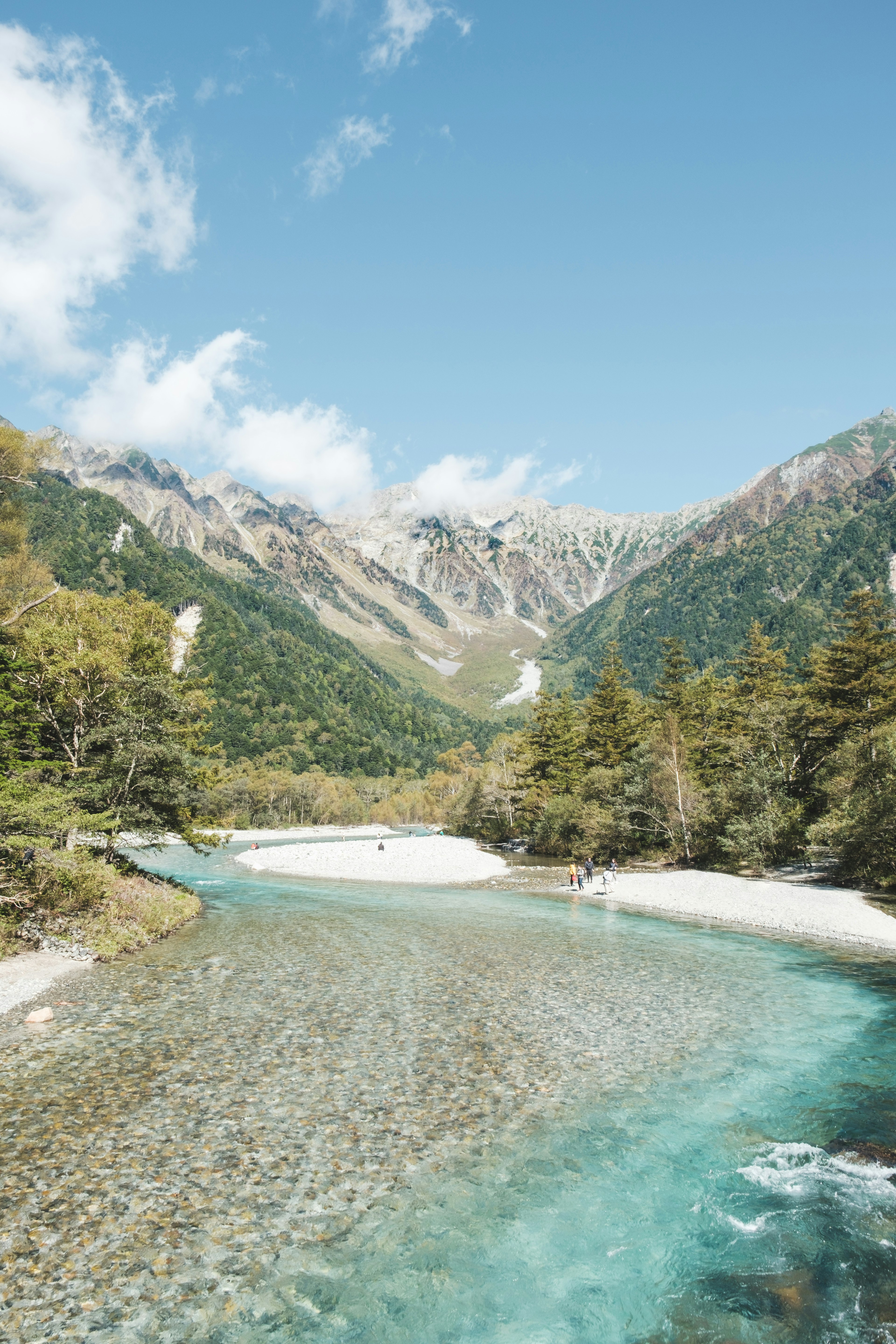 Río pintoresco que fluye a través de un valle rodeado de montañas cielo azul claro