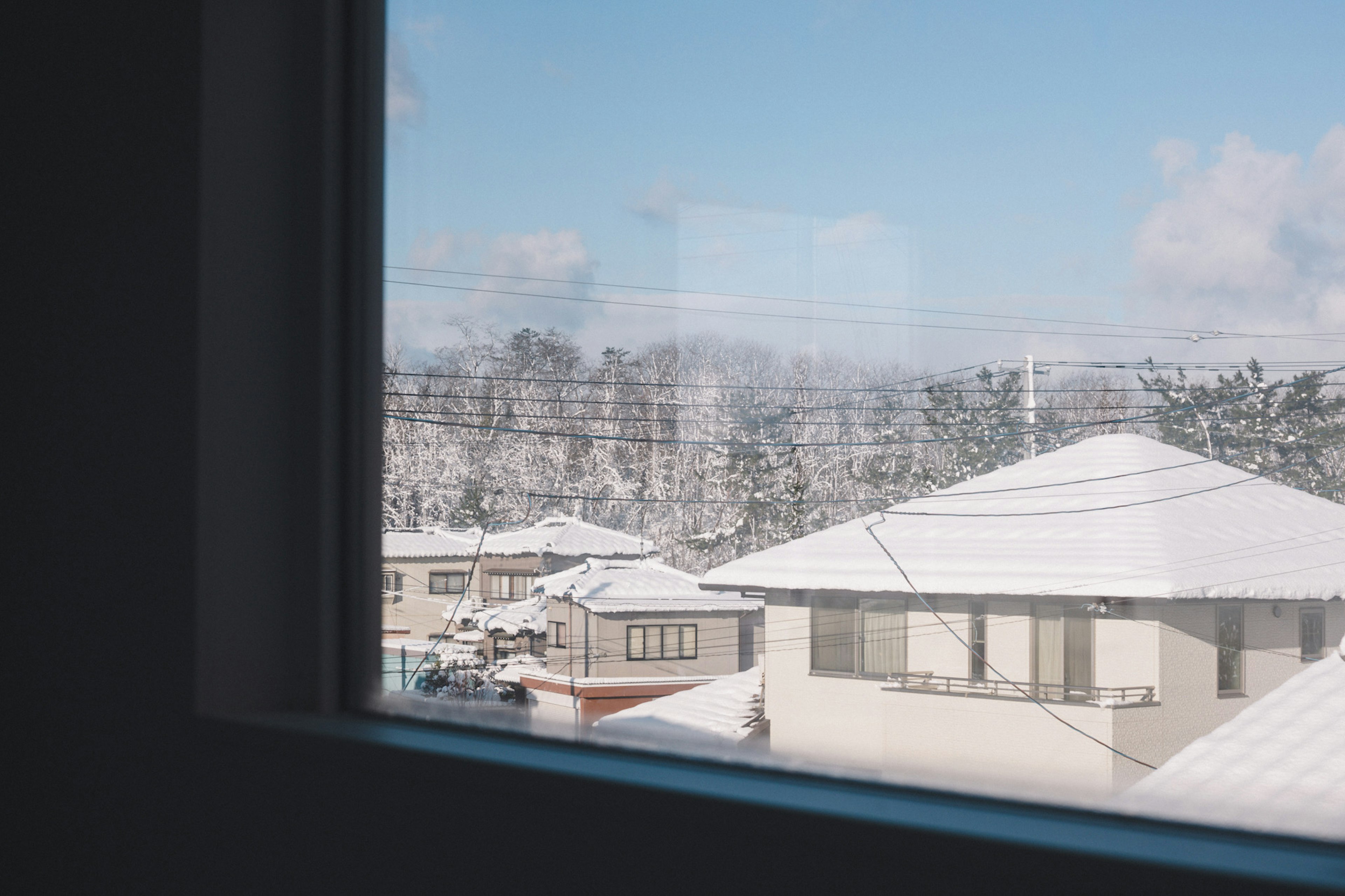 Blick auf schneebedeckte Häuser und blauen Himmel